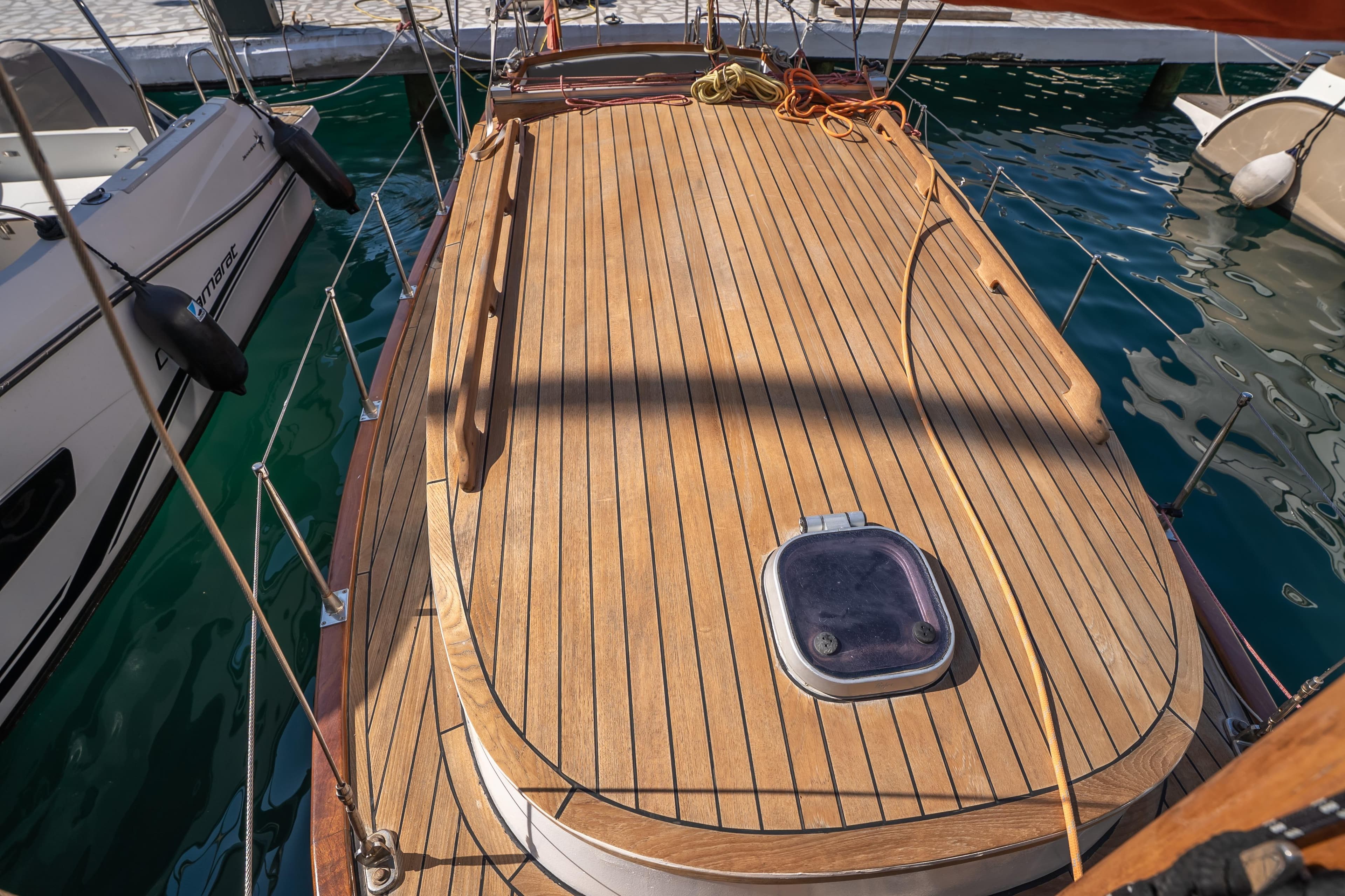 Wooden deck of a 1999 Custom Lykia boat docked at a marina.