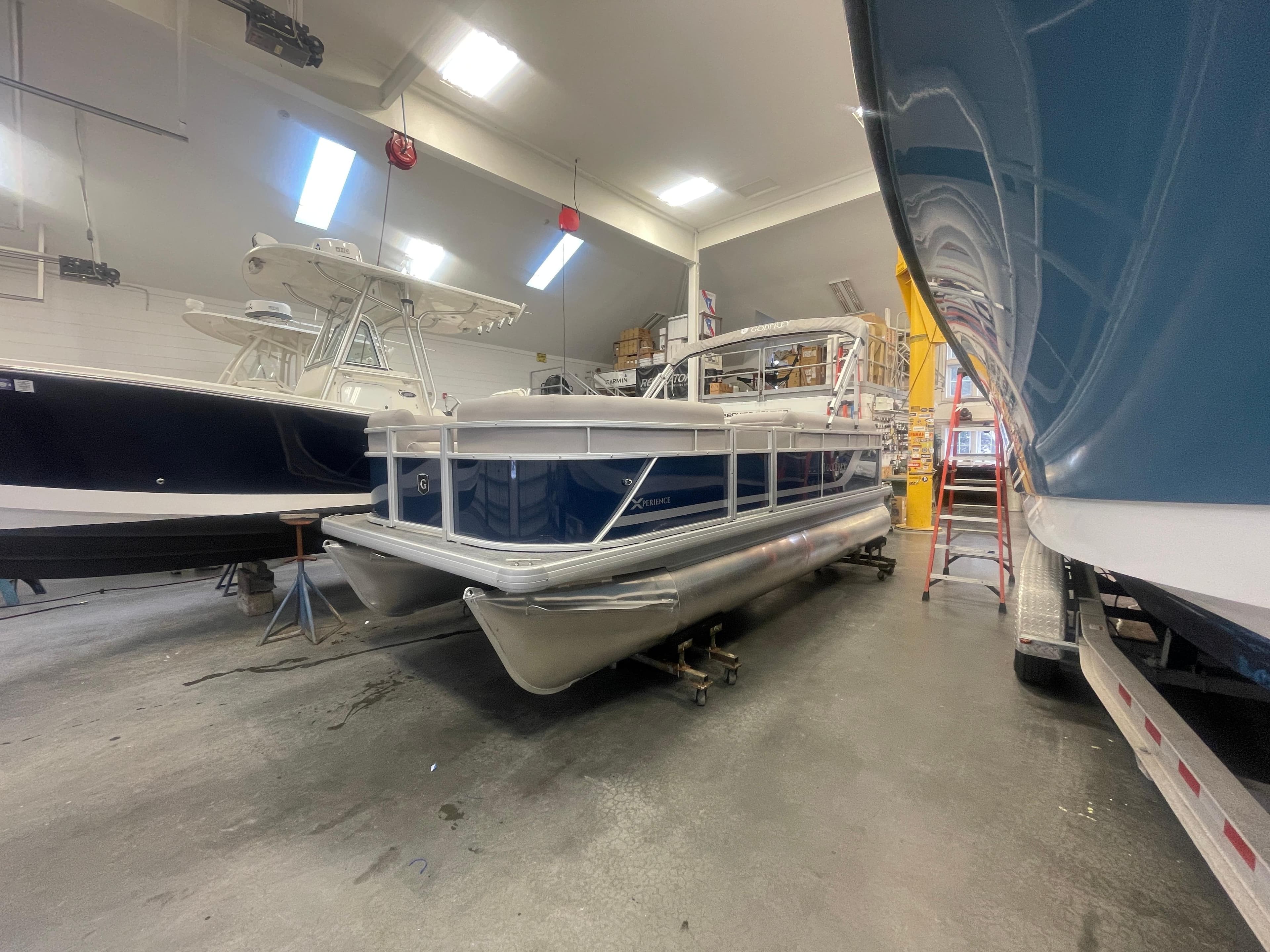 2024 Godfrey Xperience 1880 FX pontoon boat in a showroom.