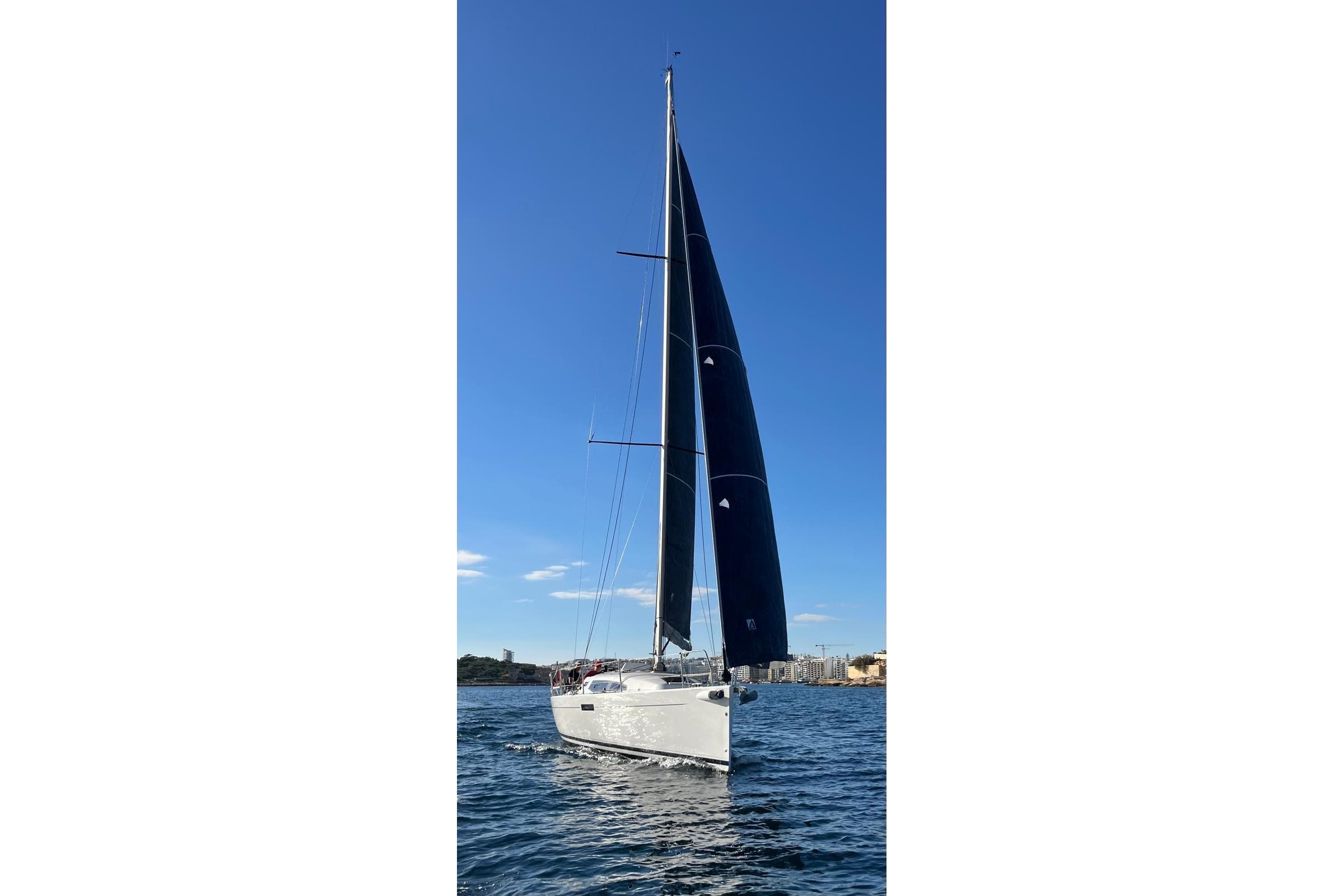 2018 J-Composites J/112E sailboat on open water under clear blue sky.