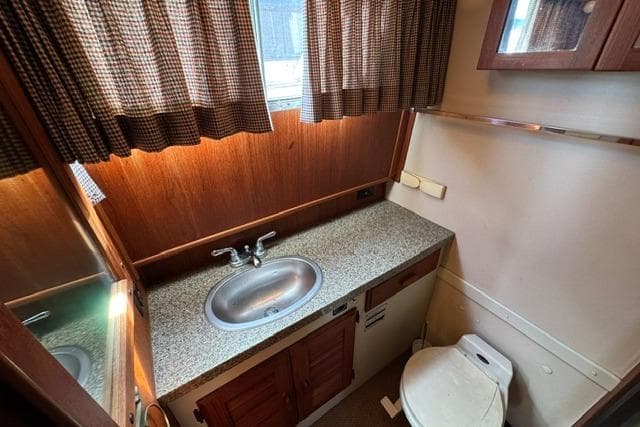 1984 Tollycraft 43 Motor Yacht bathroom with sink, countertop, and toilet.