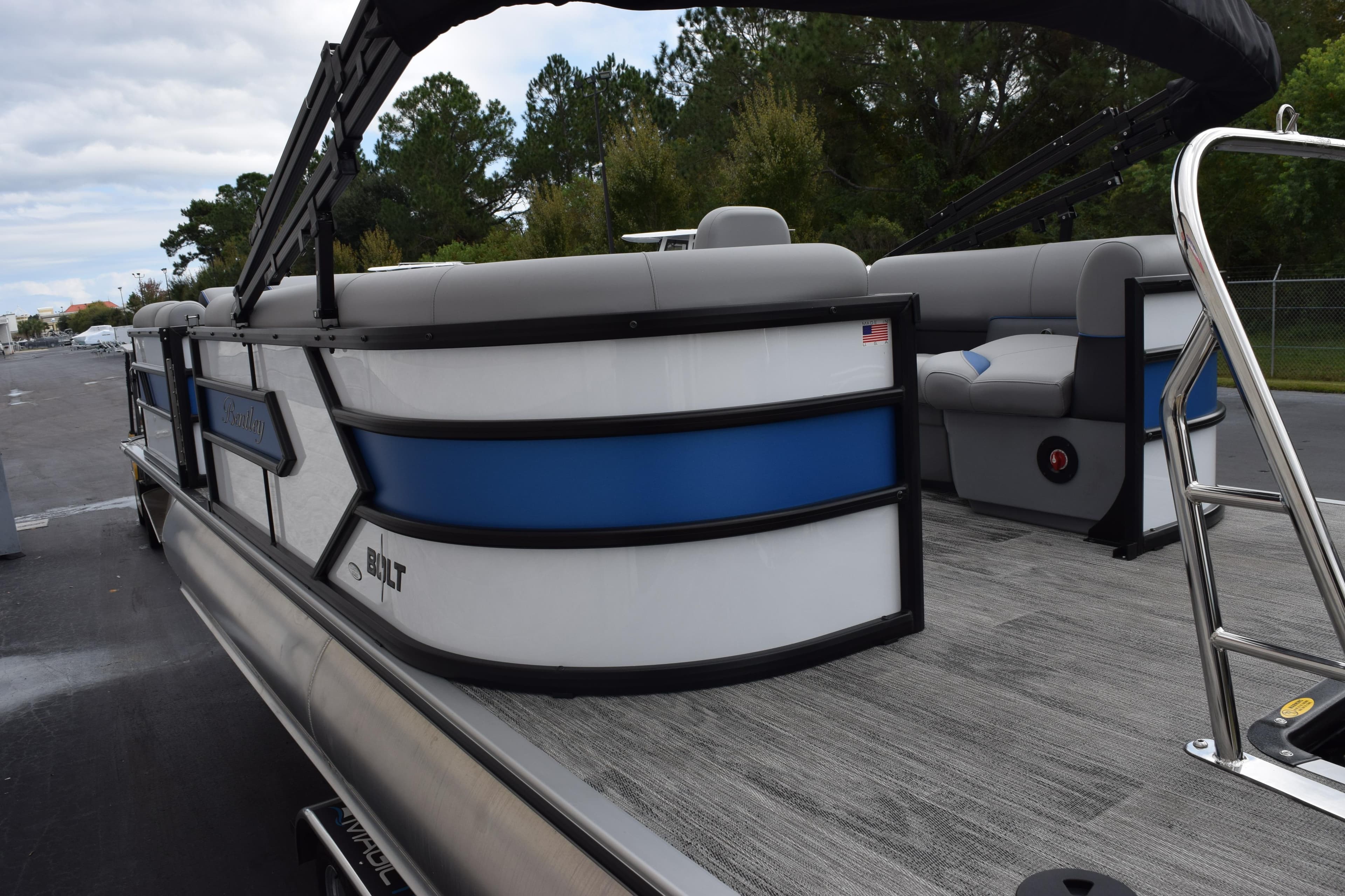 2026 Bentley Pontoons Bolt 223, sleek design with blue and white accents, docked outdoors.