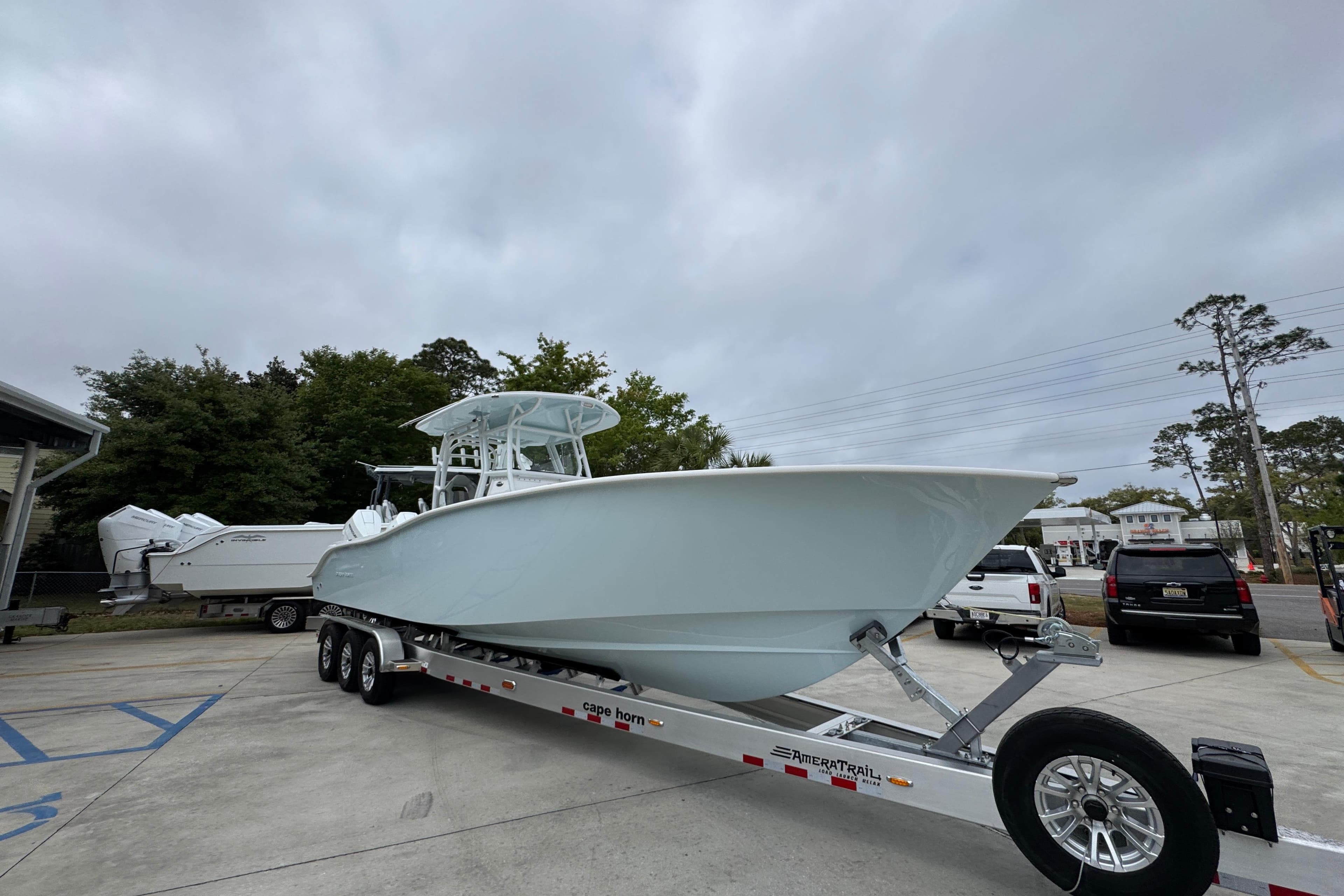 2026 Cape Horn 34 XS boat on trailer in parking lot, cloudy sky background.