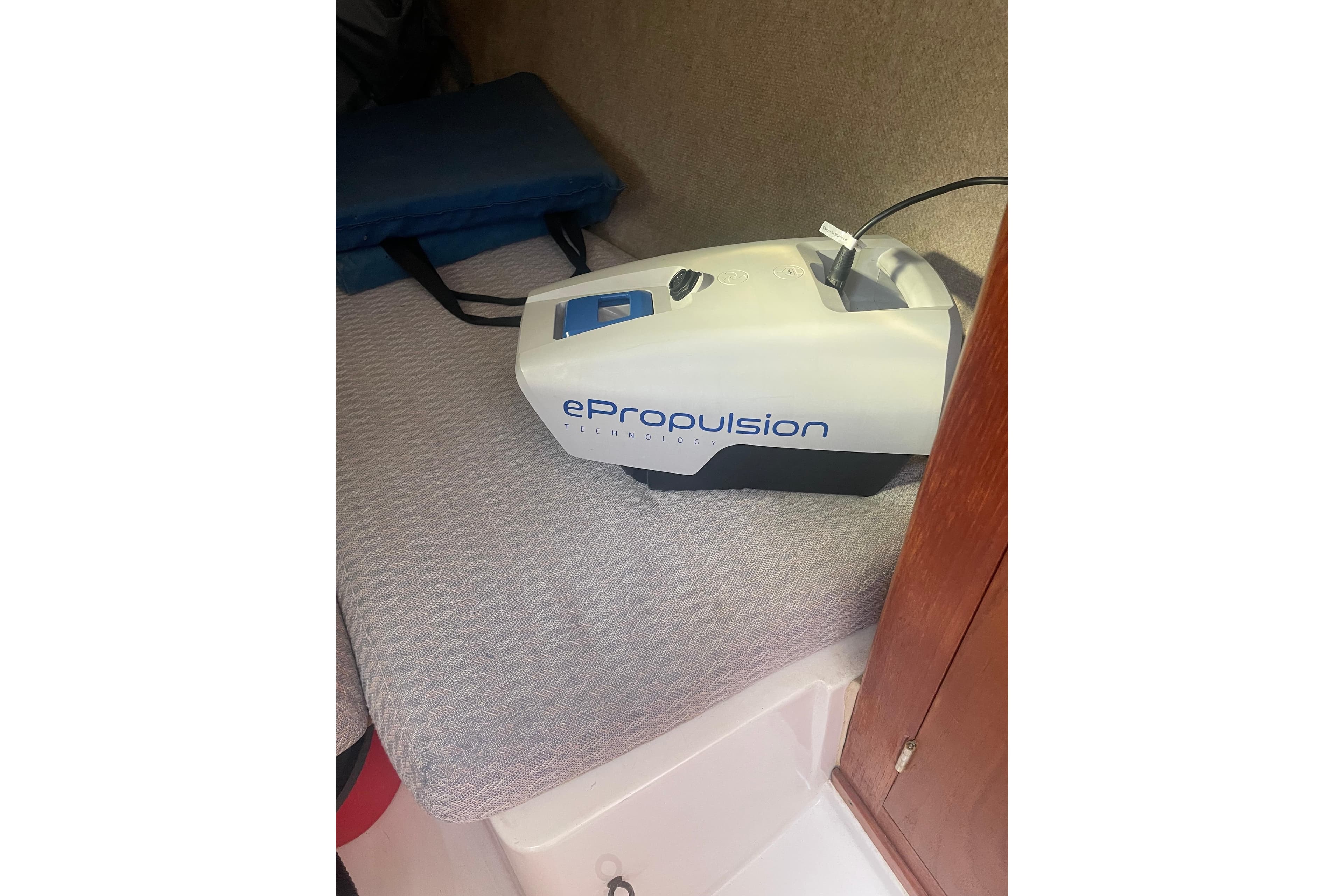 ePropulsion device inside 1987 Beneteau 31 boat cabin, resting on a cushioned surface.