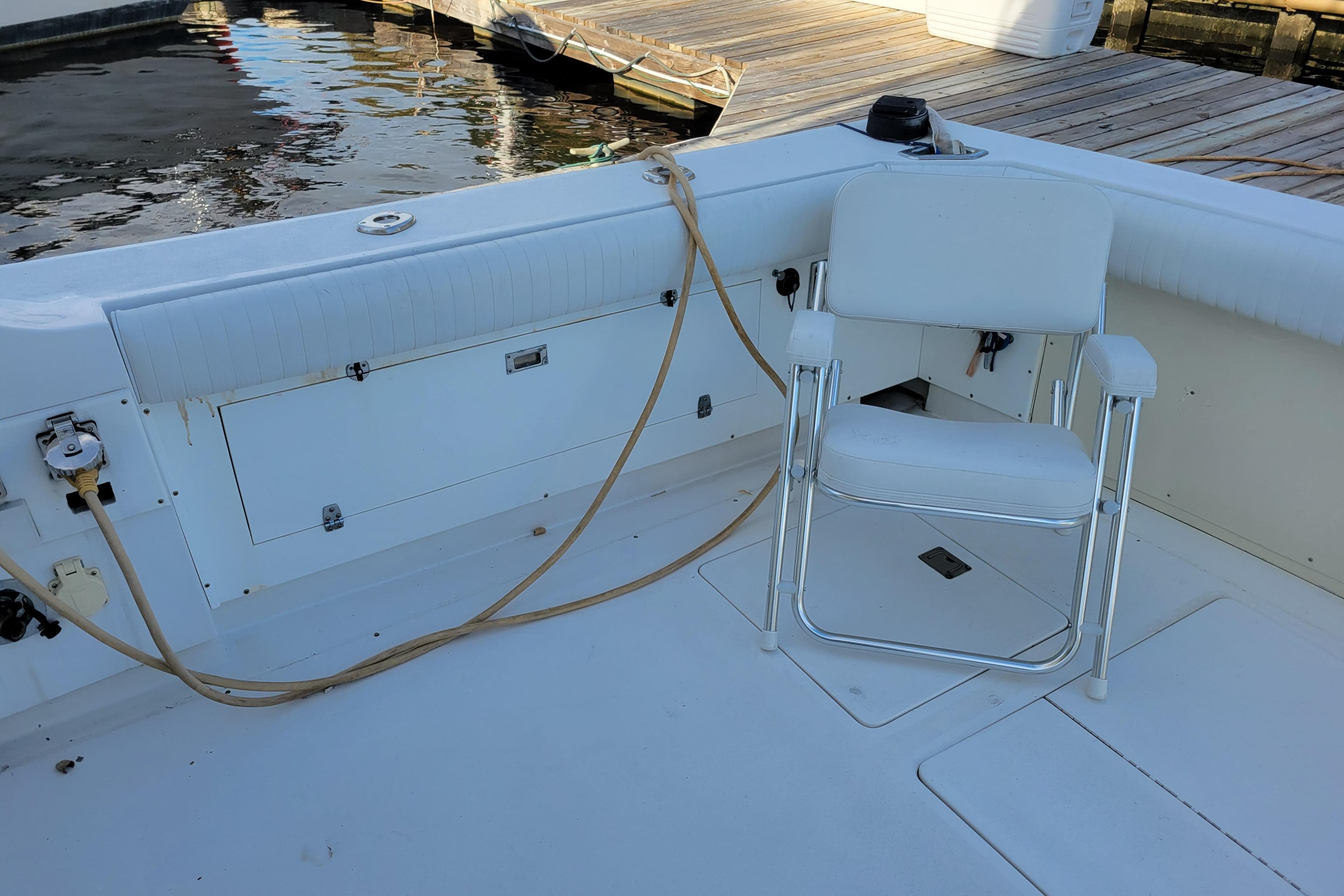 1979 Bertram 38 Convertible boat deck with white chair and dock view.