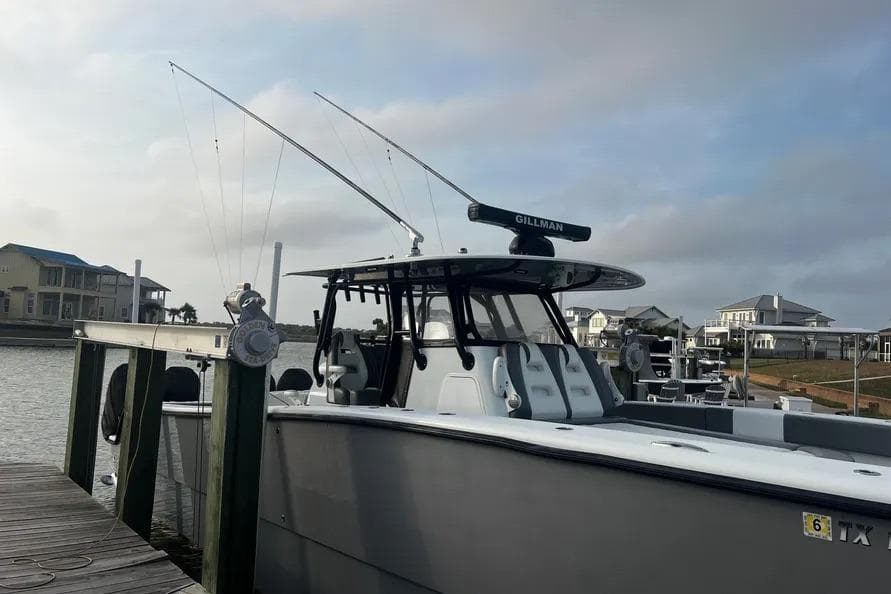 2022 Freeman 37VH boat docked, featuring fishing rods and coastal homes in the background.