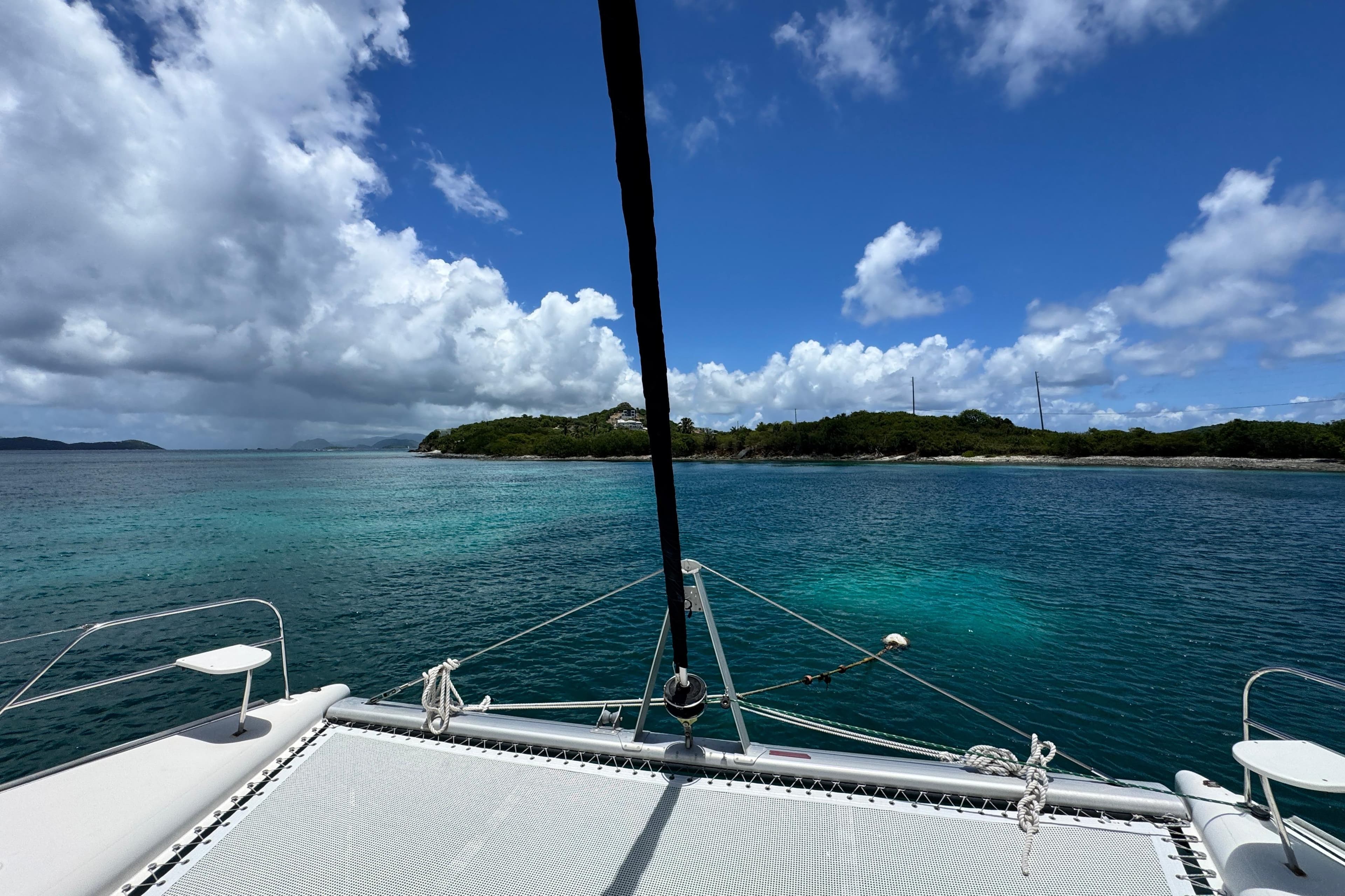 Catamaran Leopard 46 sailing near tropical island, clear blue sky and ocean, 2011 model.