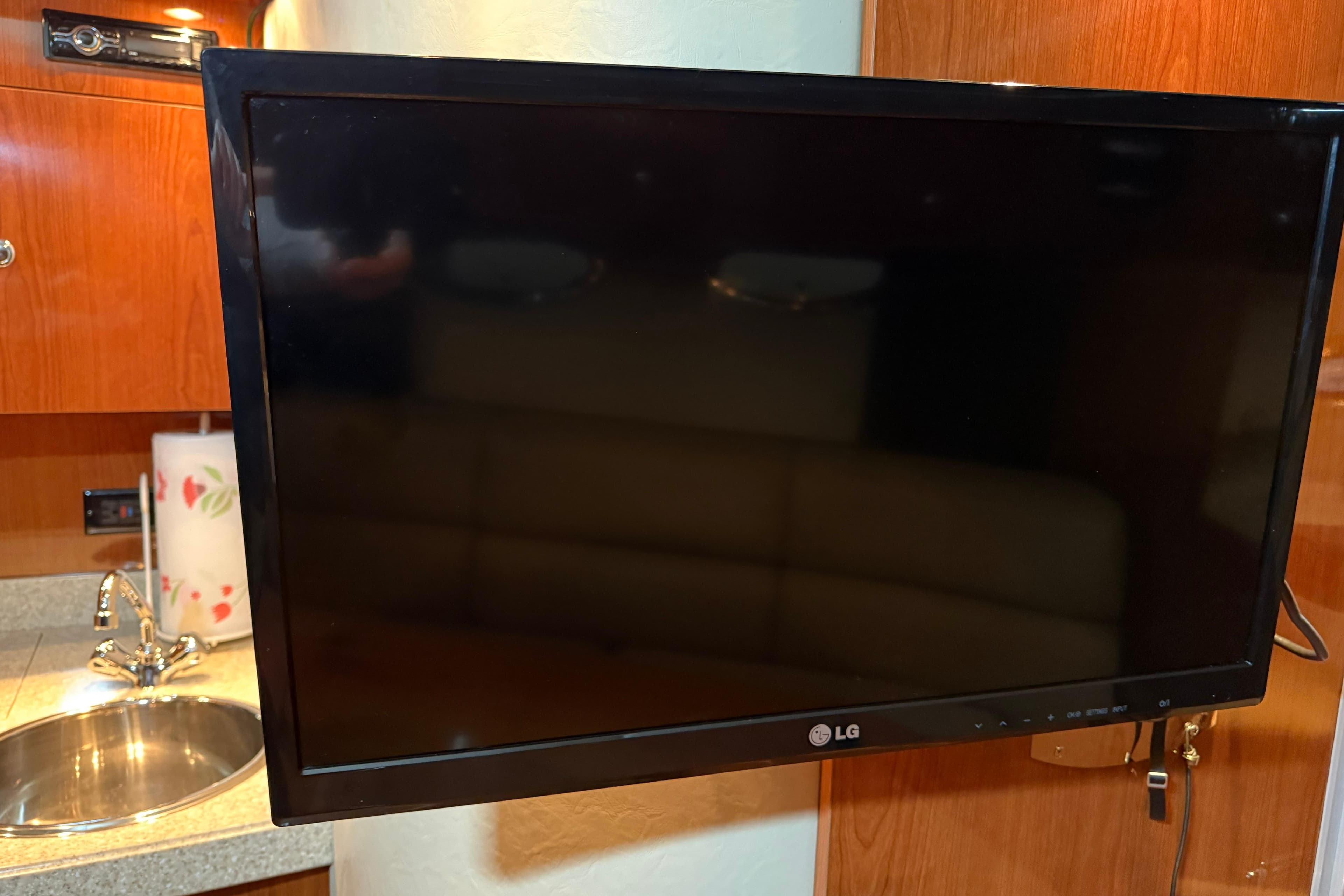 LG TV in 2007 Regal Commodore 3760 IO yacht interior, near sink and wooden cabinetry.