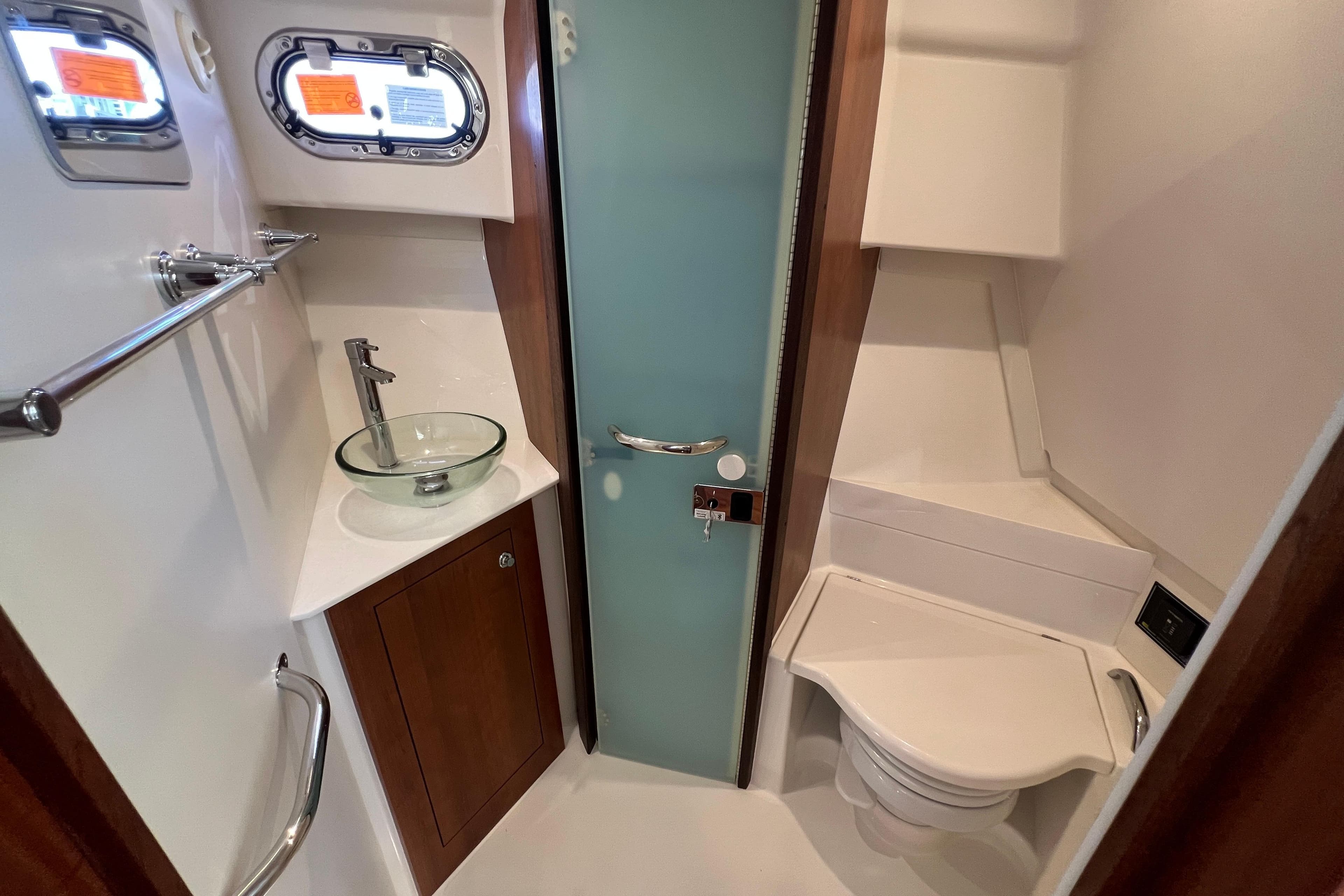 2026 Pursuit OS 355 Offshore bathroom with glass sink and modern fixtures.