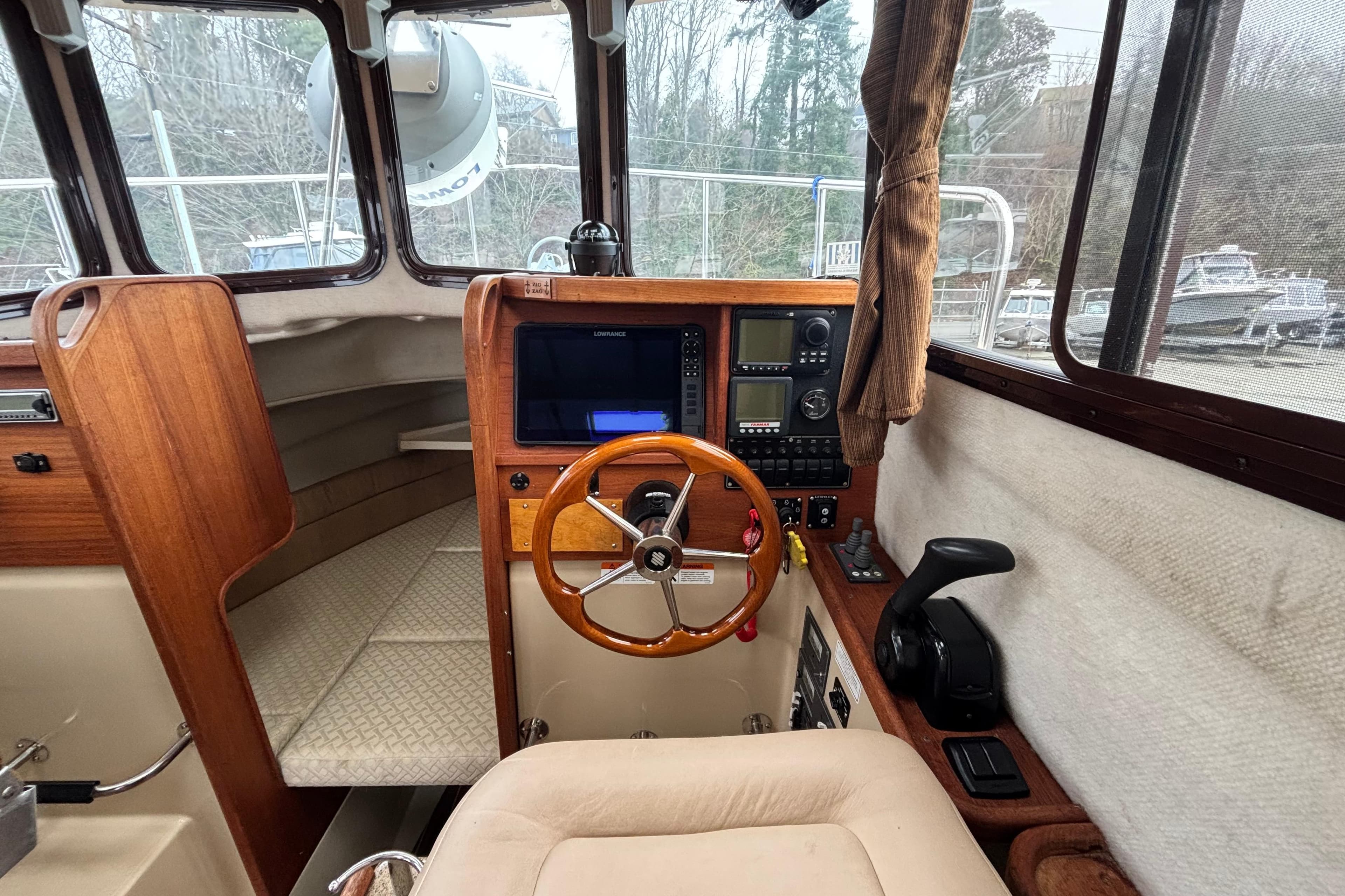 Interior of a 2010 Ranger Tugs R-25 SC with wooden steering wheel.