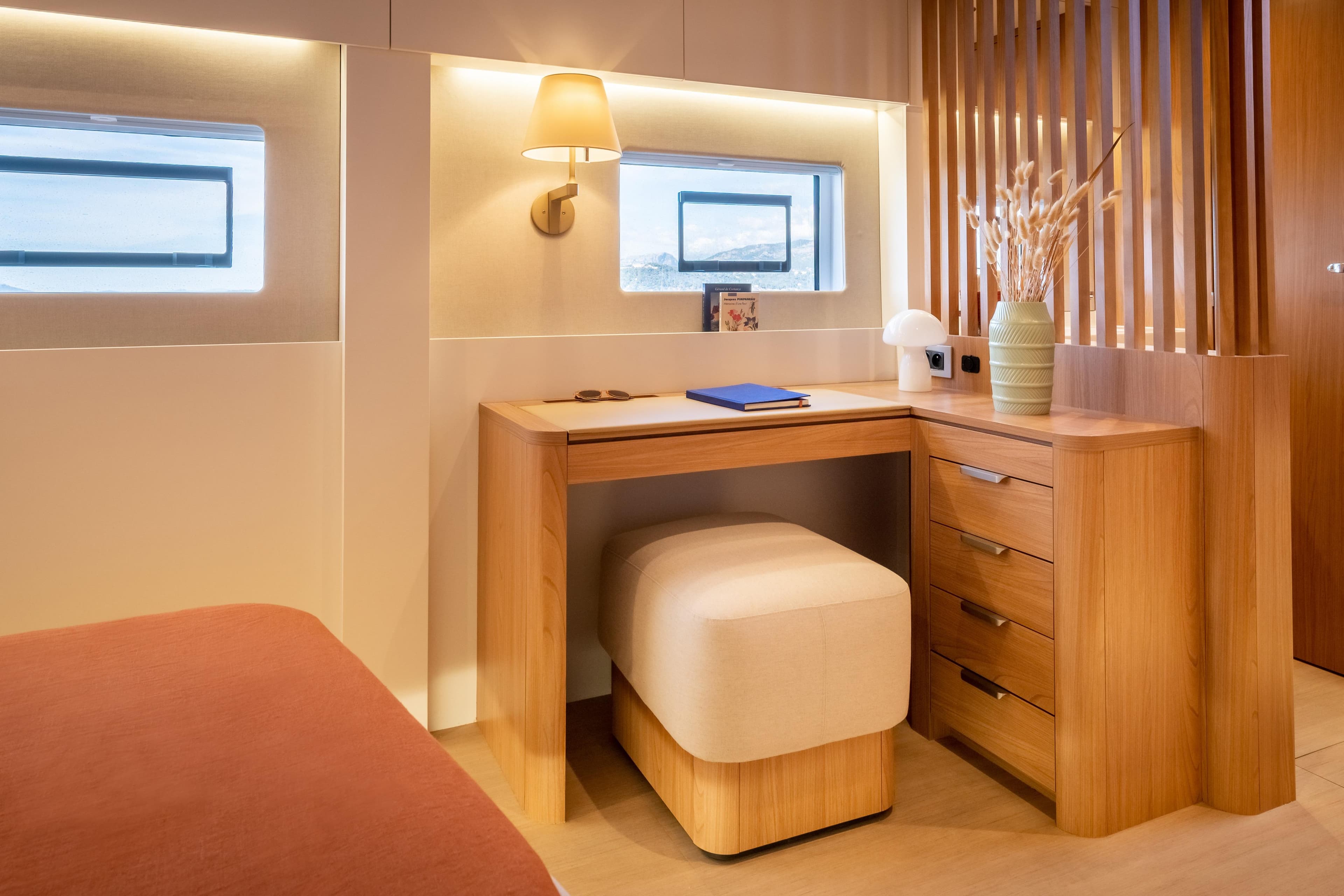 Luxurious interior of 2026 Bali 5.8 yacht with elegant wooden desk and cozy seating.