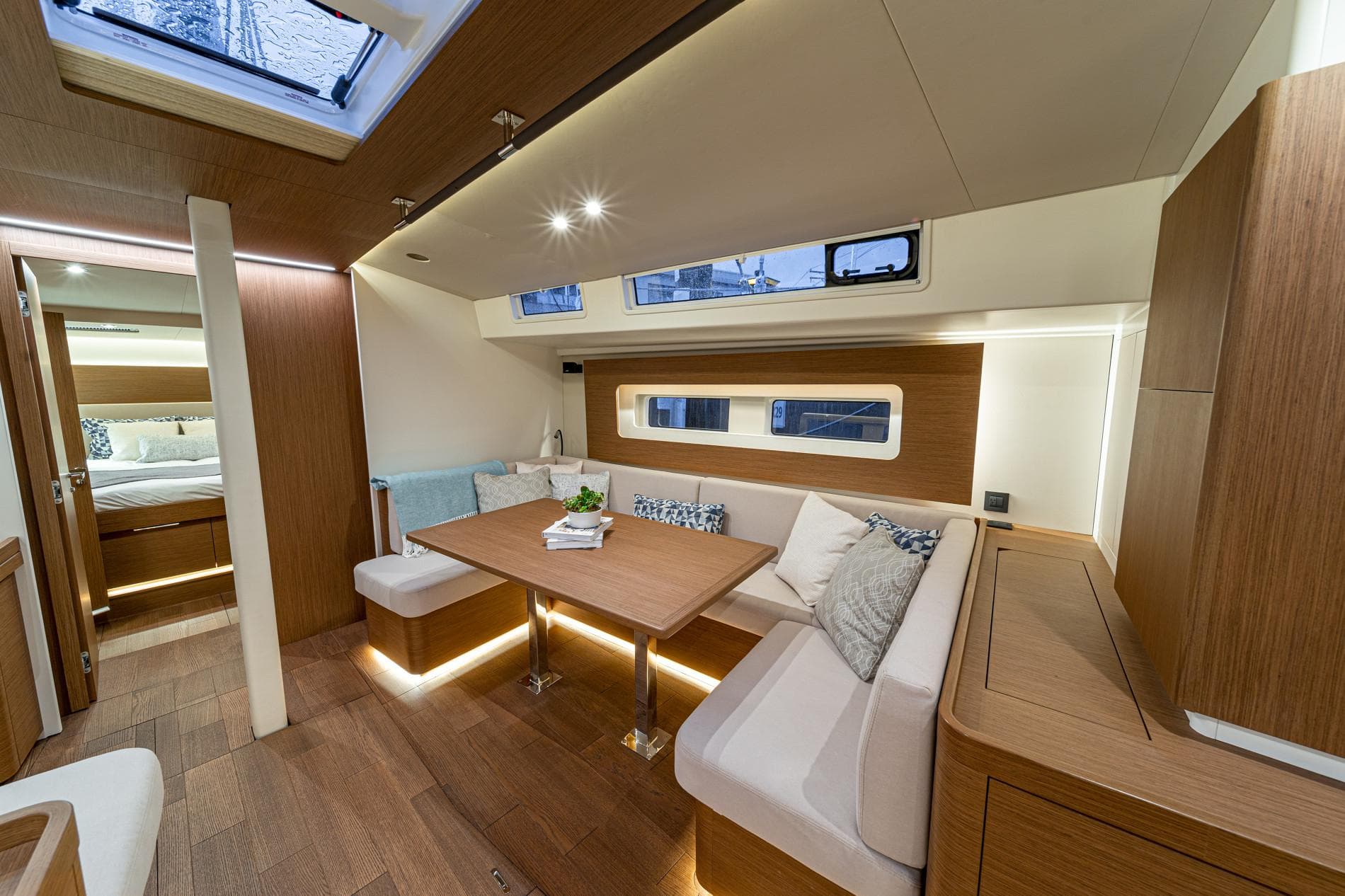 Luxurious interior of 2025 Beneteau Oceanis Yacht 54 with modern seating and wooden finishes.
