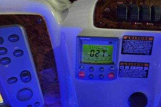 Control panel of a 2003 Meridian 381 Sedan boat with digital display and warning labels.