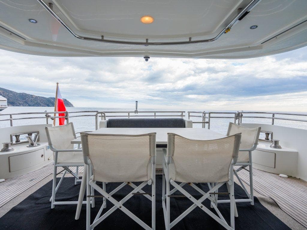 Outdoor seating on 2008 Trader 64 Sunliner yacht, ocean view, cloudy sky.