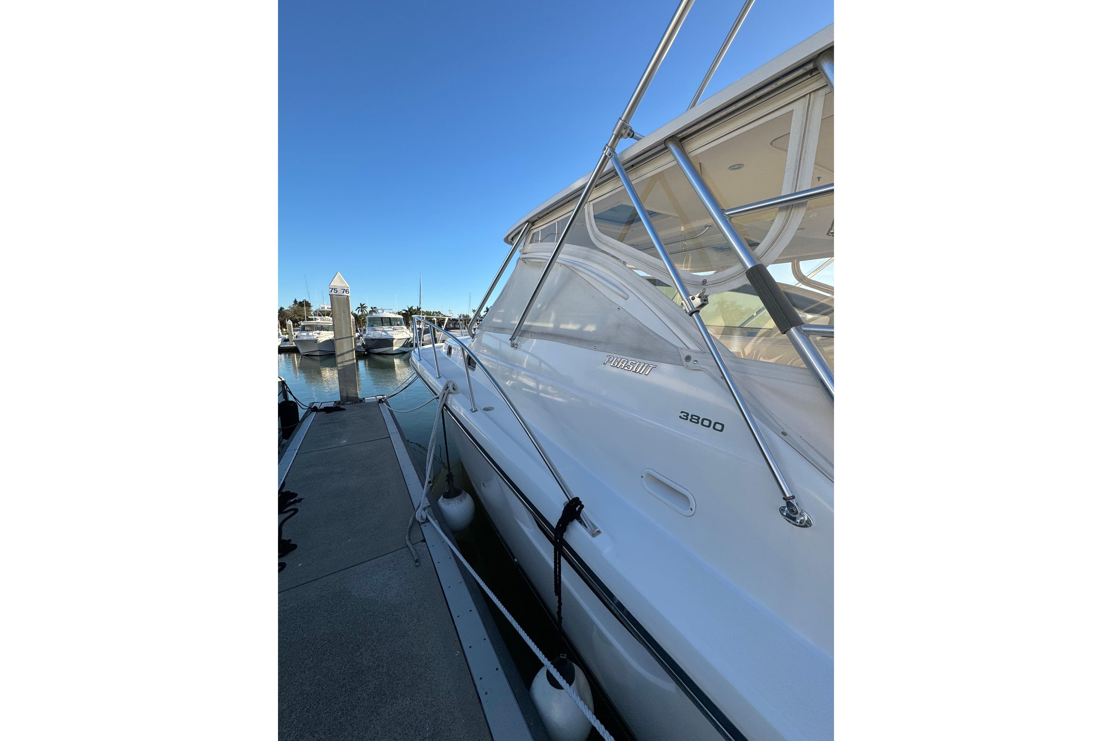 2002 Pursuit 3800 Express yacht docked at marina under clear blue sky.