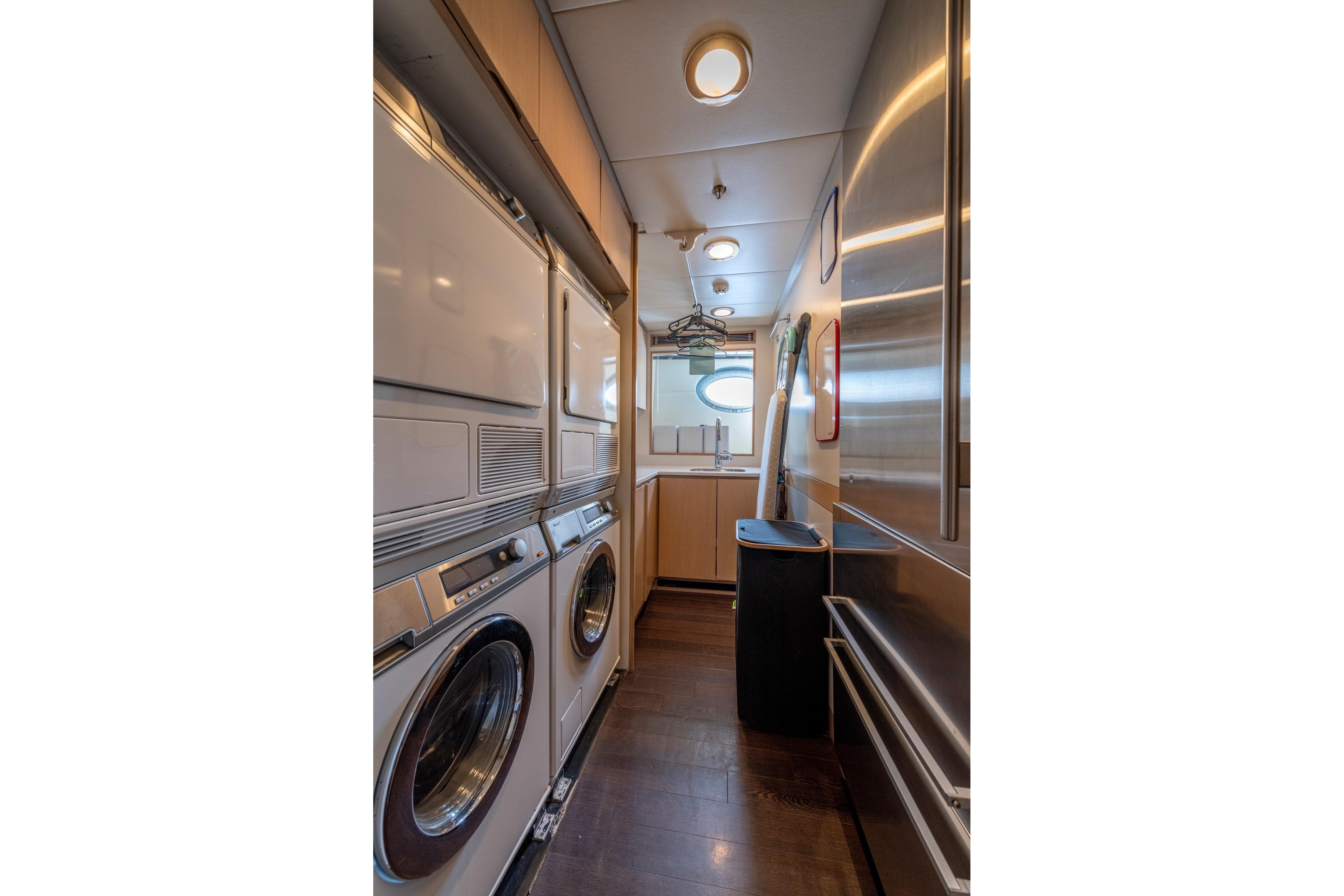 Laundry room aboard 2008 Palmer Marine PJ150 yacht with washer, dryer, and ironing board.