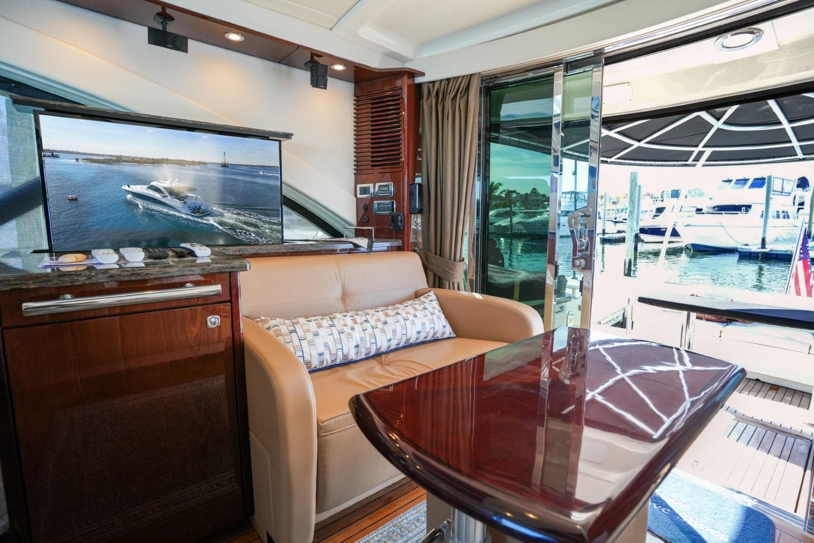 Luxurious interior of 2013 Sea Ray 610 Sundancer yacht with elegant seating and marina view.