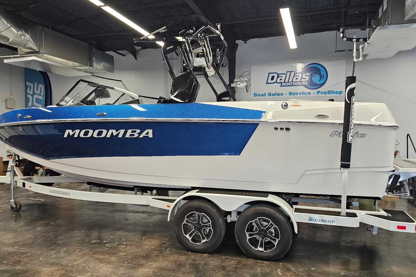 2024 Moomba Mojo boat in showroom, blue and white design, on trailer.