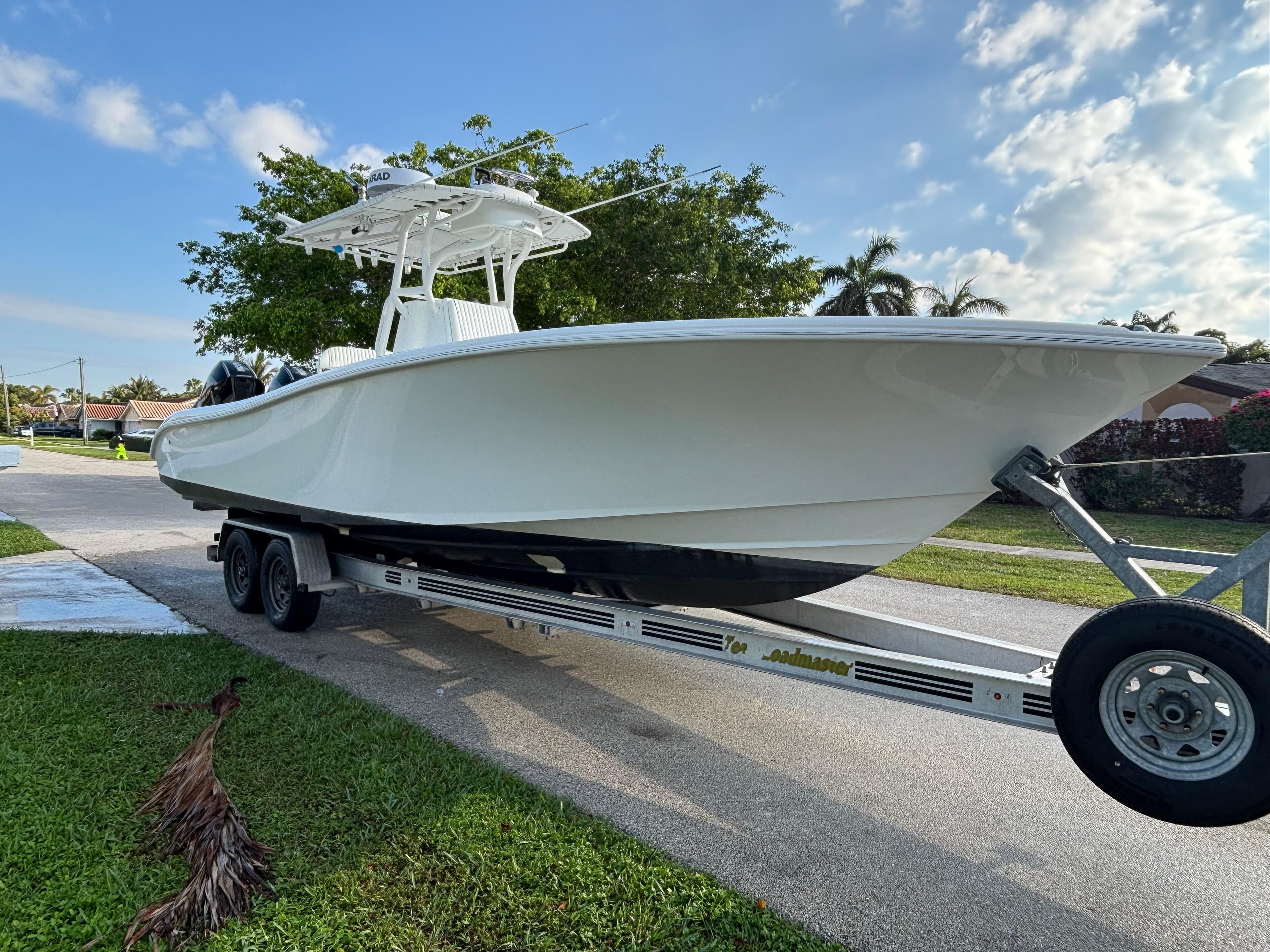 2012 Yellowfin 29 boat on trailer, parked on a suburban street.