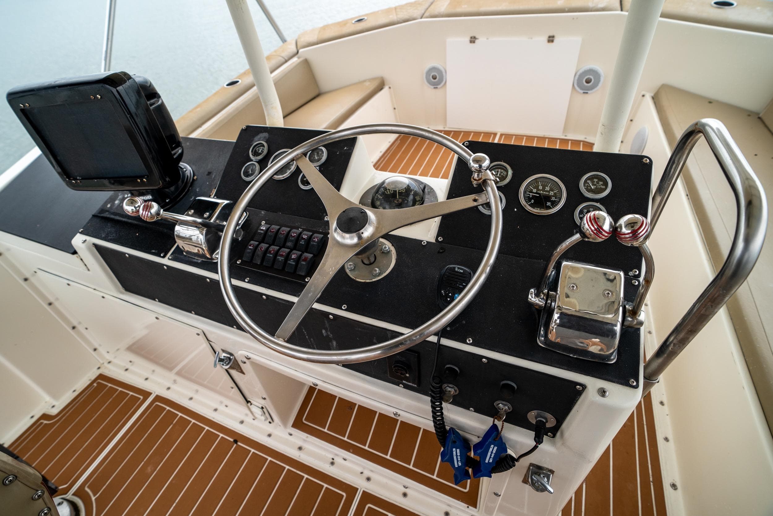 1984 Hatteras 52 Convertible boat helm with steering wheel and control panel.