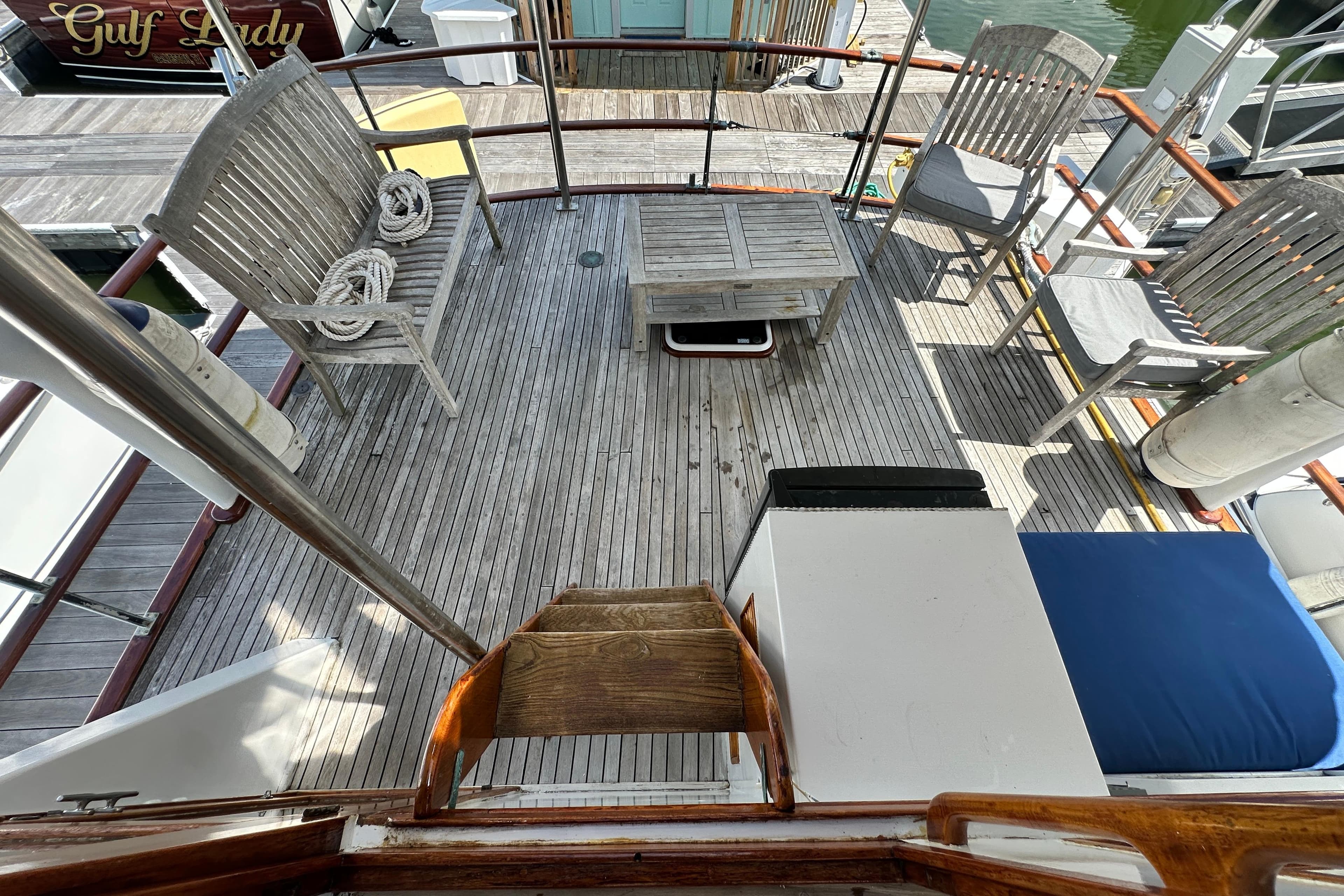 1980 Island Gypsy Flush Aft Deck Trawler-Motor Yacht with wooden seating and table on deck.