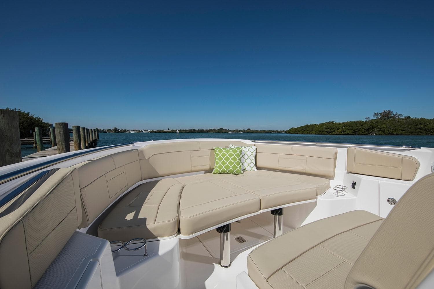 Manufacturer Provided Image: 2021 Pursuit S 328 Sport boat with beige seating and green cushion on the water.