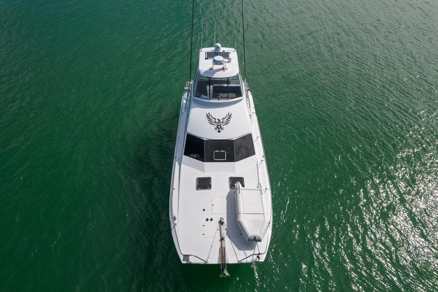 1991 Ron Given Power Catamaran on calm green water, aerial view.