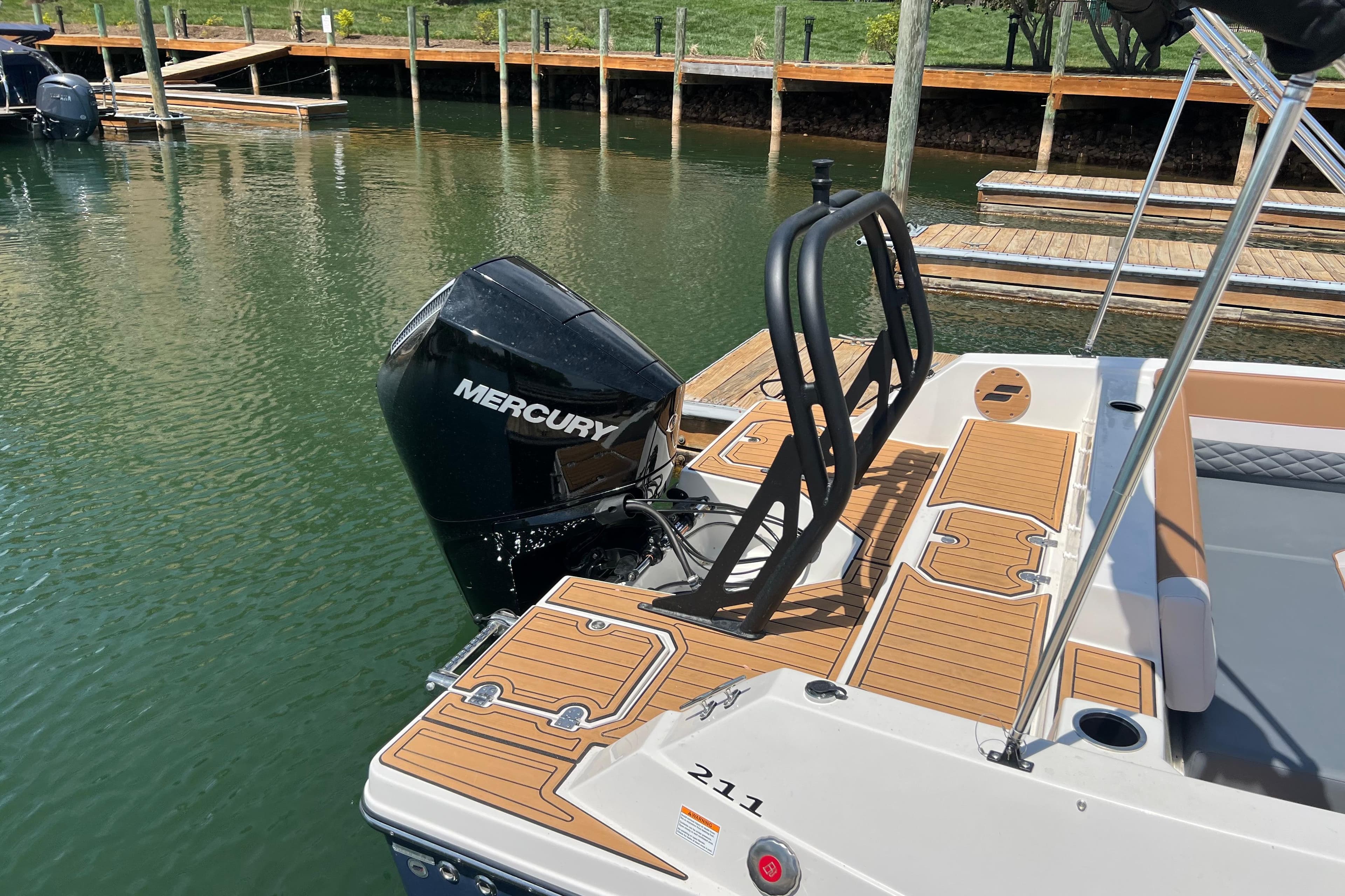2026 Starcraft SVX 211 OB boat with Mercury outboard engine docked on calm water.