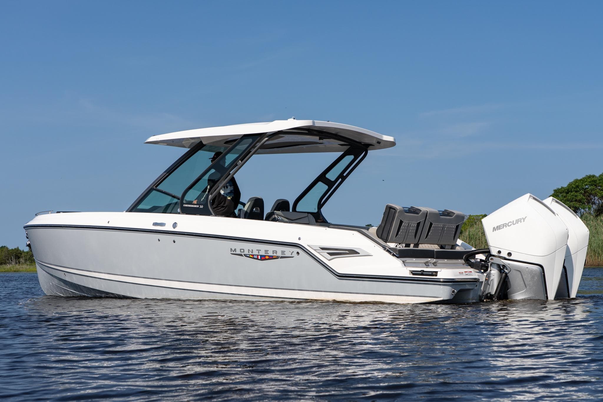 2026 Monterey Elite 30 OB boat on water, featuring sleek design and Mercury outboard engine.