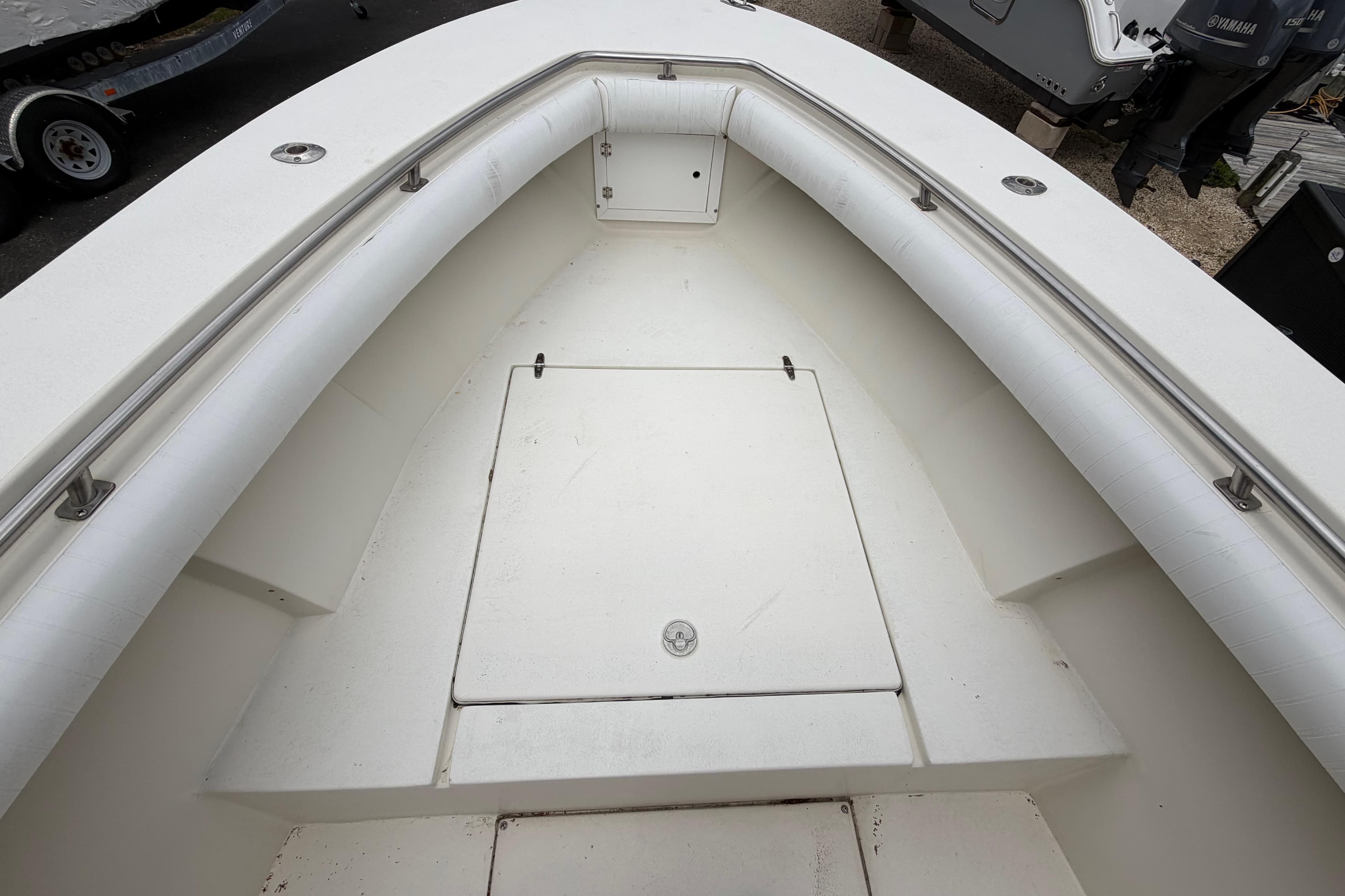 1985 SeaCraft SC 23 Classic boat interior with white seating and storage compartment.