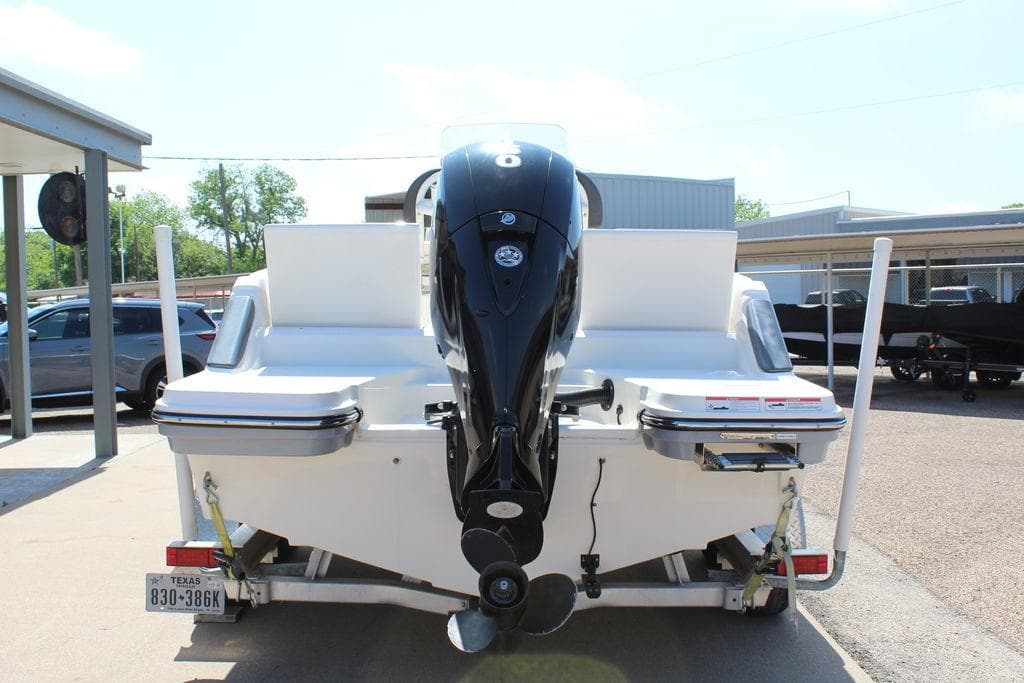2021 Bayliner T20CC boat rear view with outboard motor in a parking area.