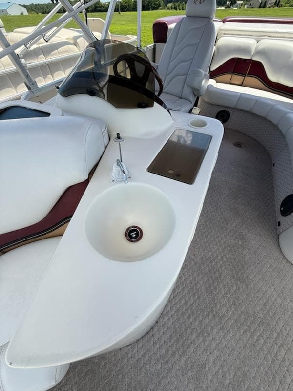 Interior of 2005 Avalon EXCALIBER 2325 boat with seating and sink.