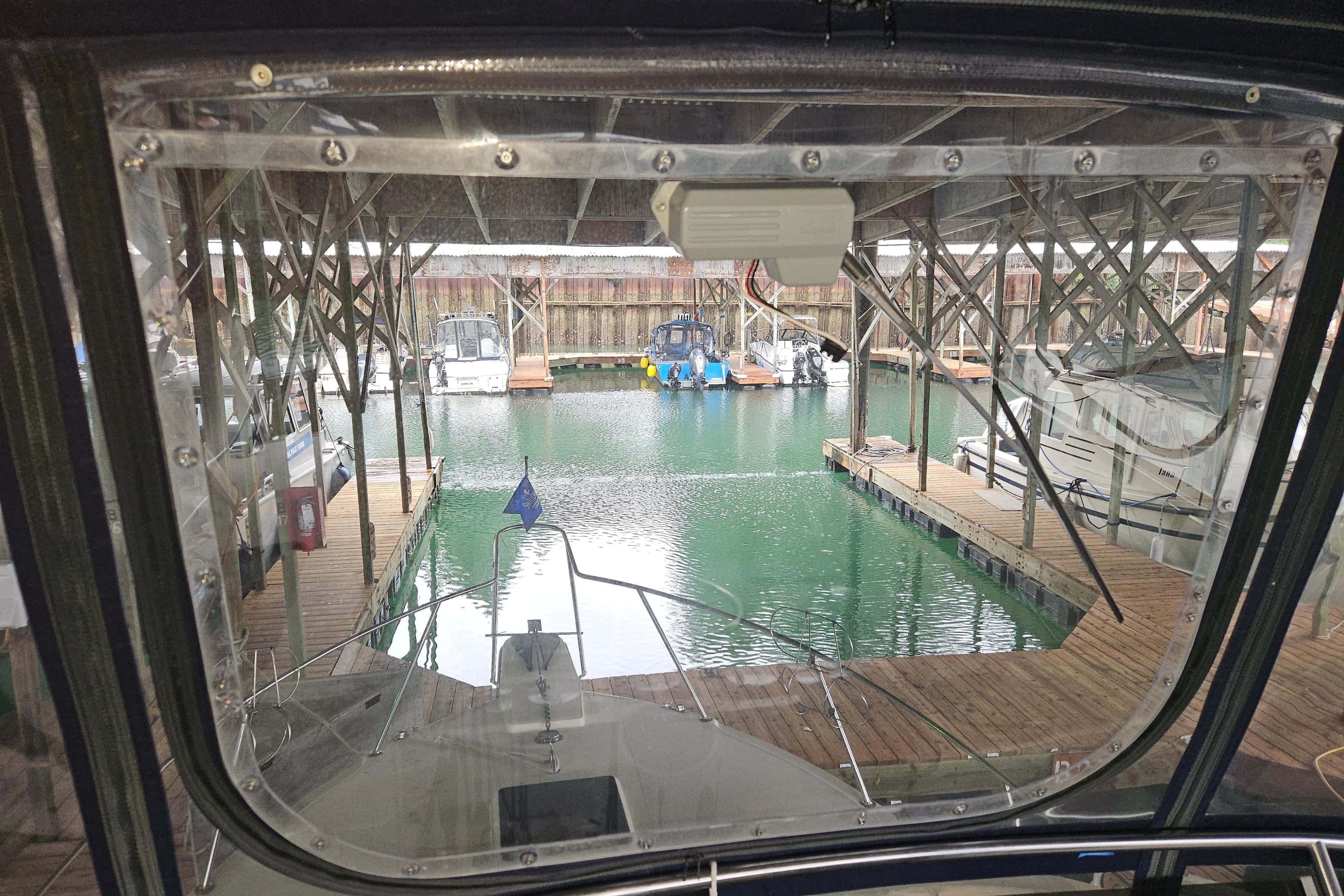 1989 Tollycraft Sport Sedan docked in a marina, viewed from the cabin.