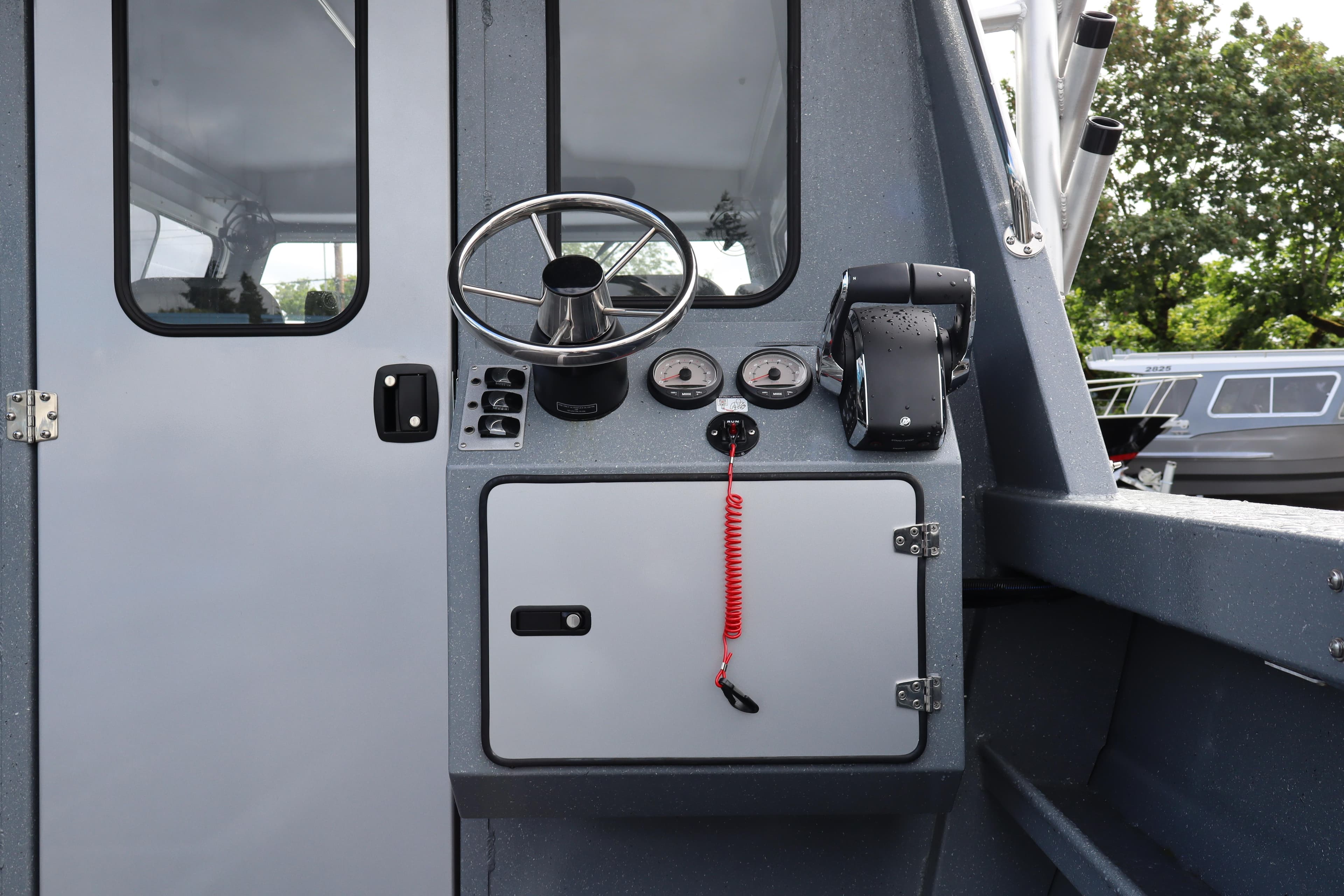 Interior helm of 2026 KingFisher 2825 Coastal Express boat with steering wheel and controls.