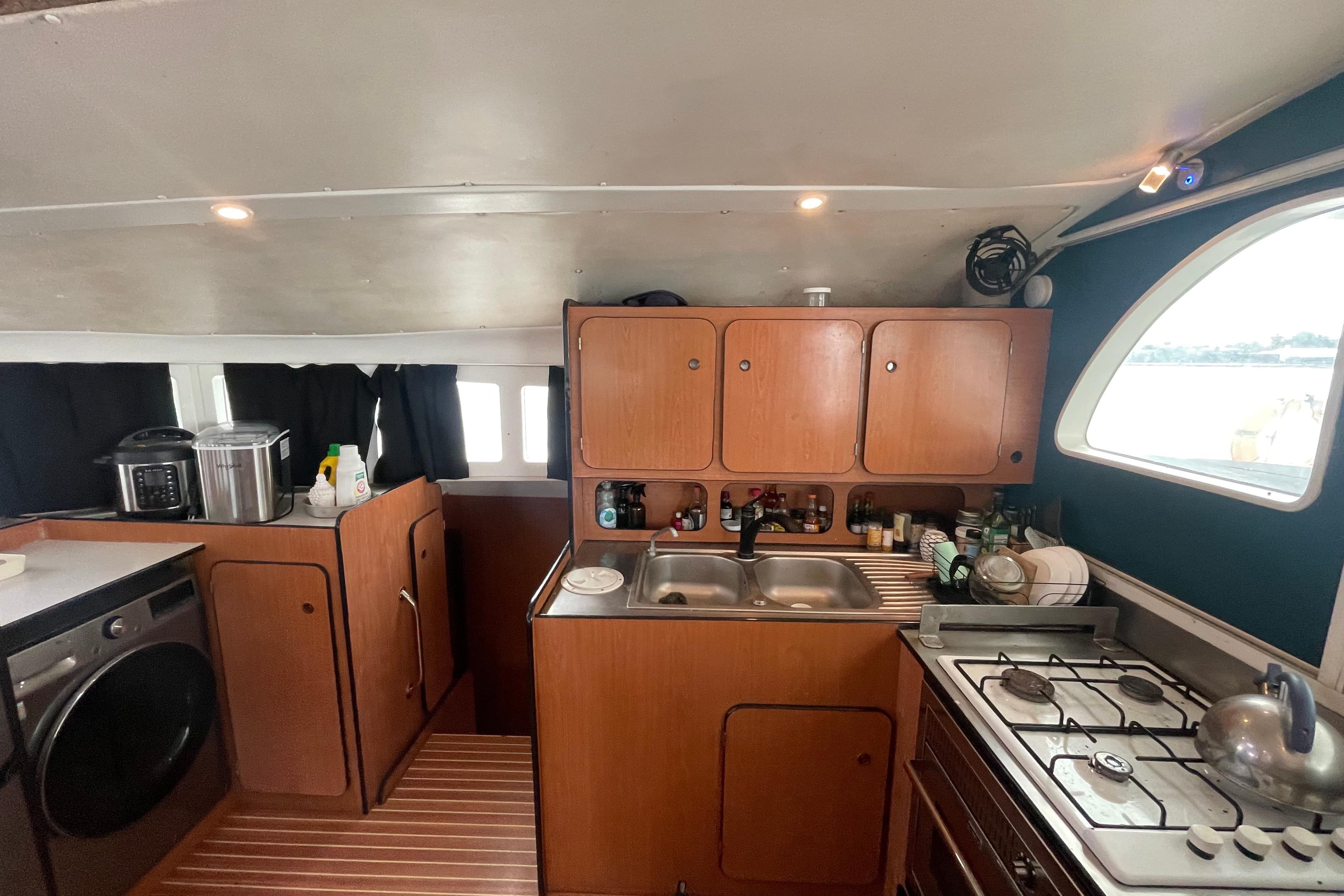 Interior of 2004 Lagoon 570 yacht kitchen with wooden cabinets and modern appliances.