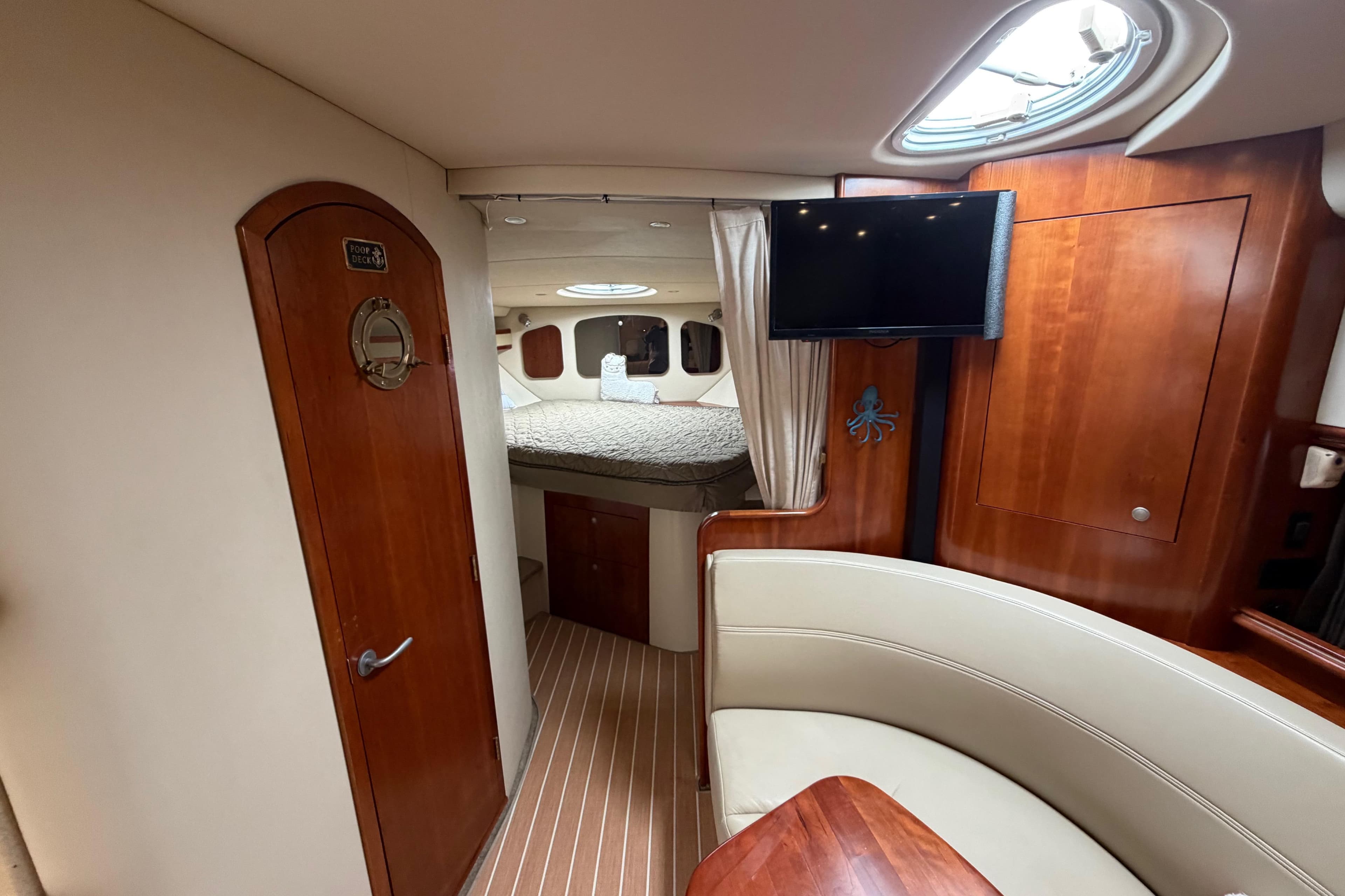Luxurious 2007 Cruisers Yachts 370 Express cabin interior with wood finishes and cozy seating.