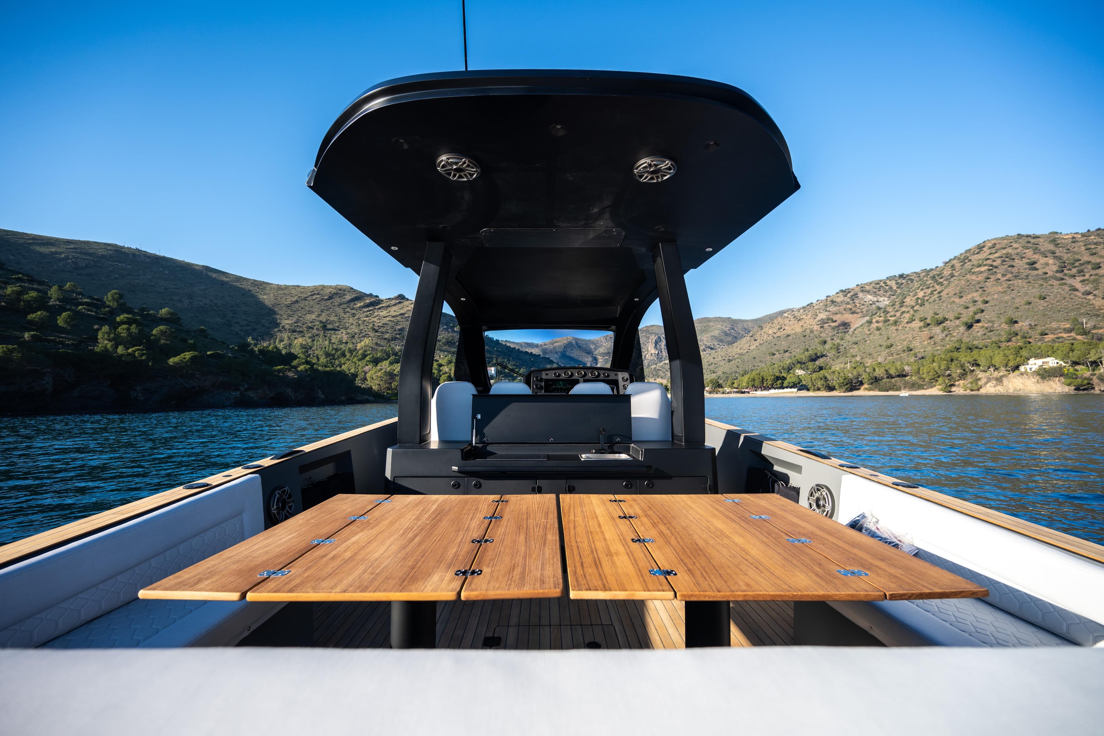 2025 Maxim Yachts 44 R on scenic water, featuring sleek design and wooden deck.