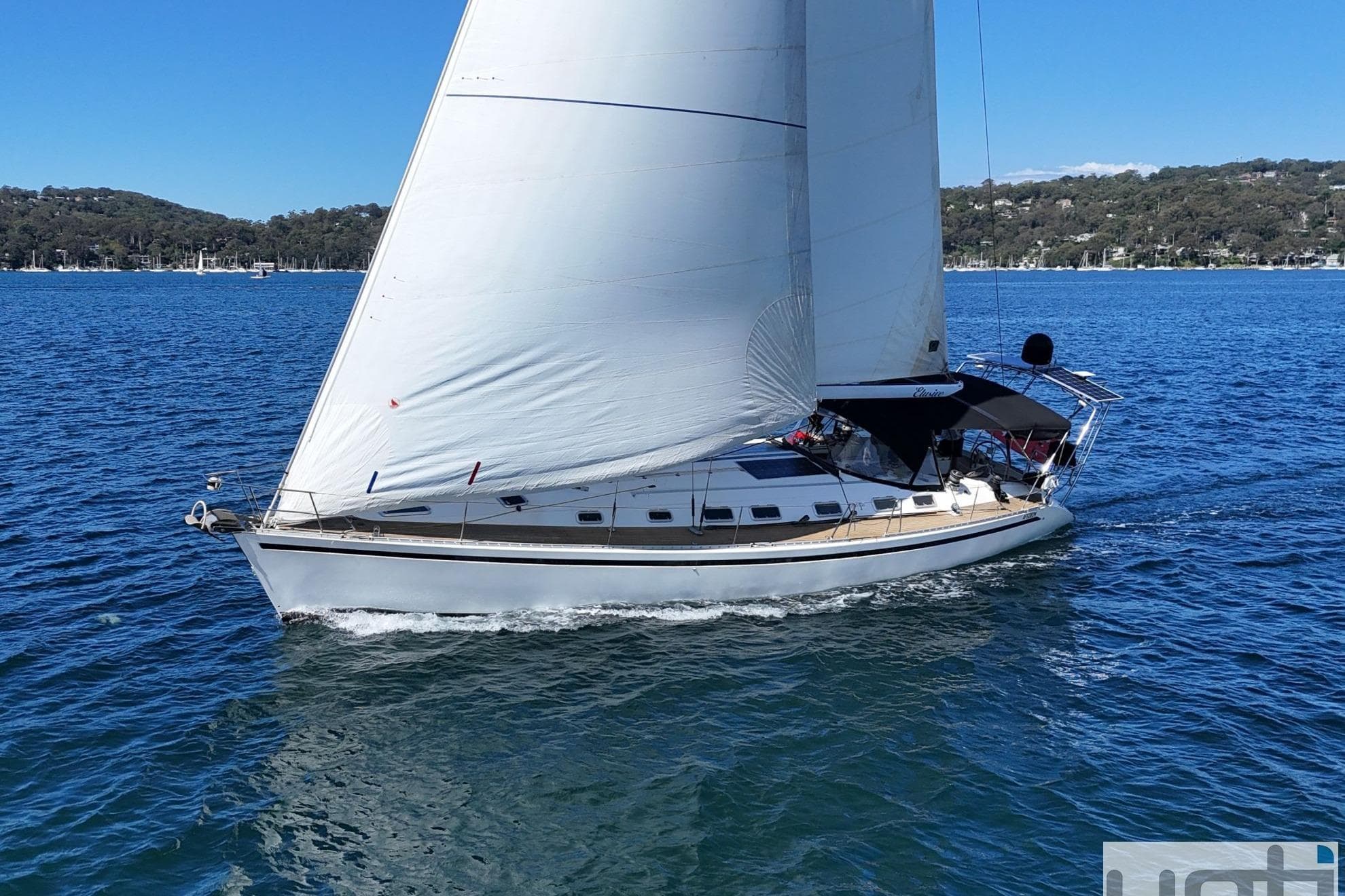 Sailing yacht Beneteau First 53f5, 1991 model, gliding on blue waters under clear skies.