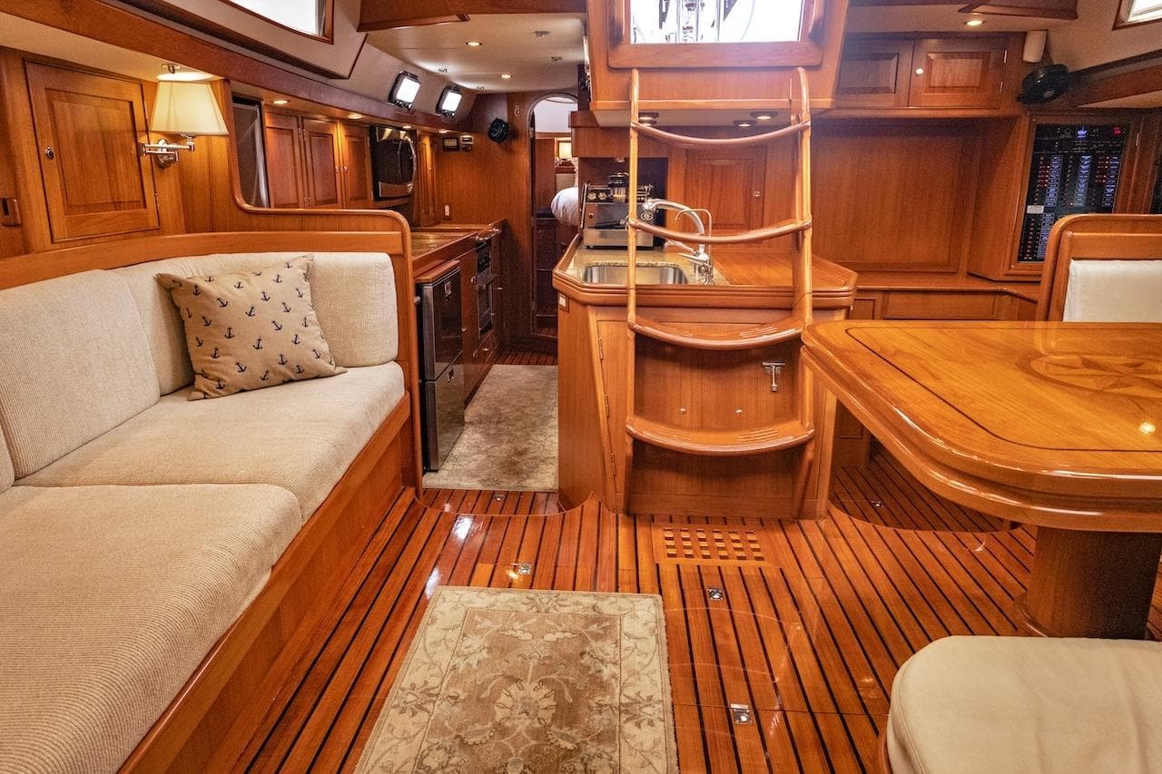 Luxurious 2012 Hylas 56 yacht interior with wooden finishes and cozy seating area.