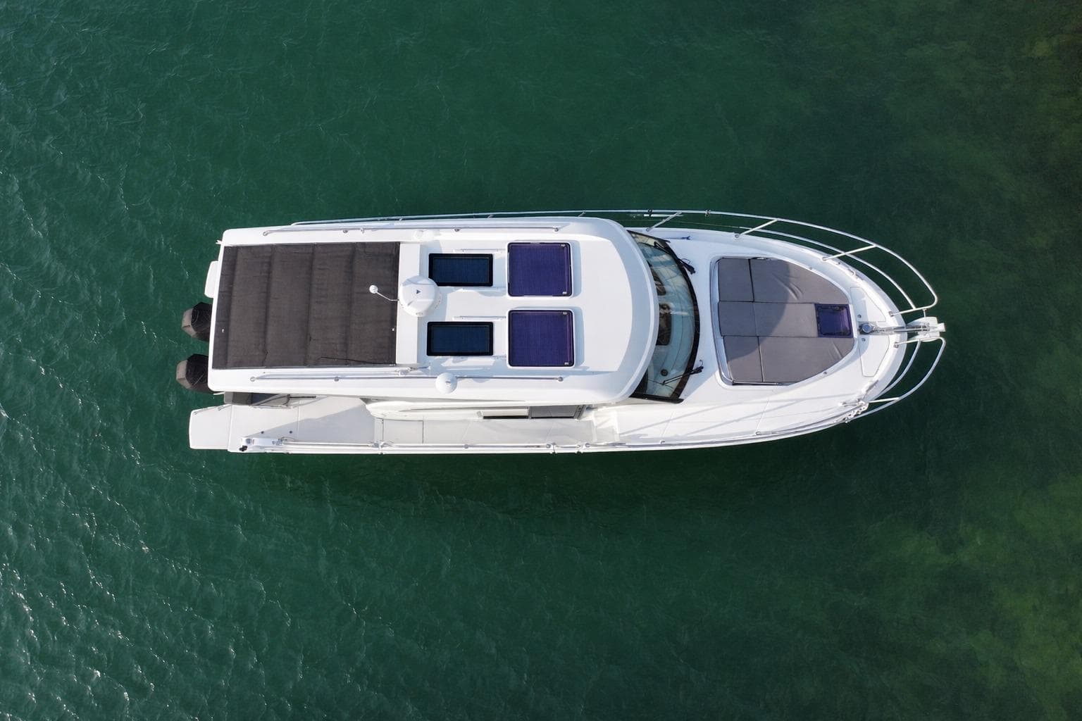 Top view of 2022 Beneteau Antares 11 Coupe on clear green water.