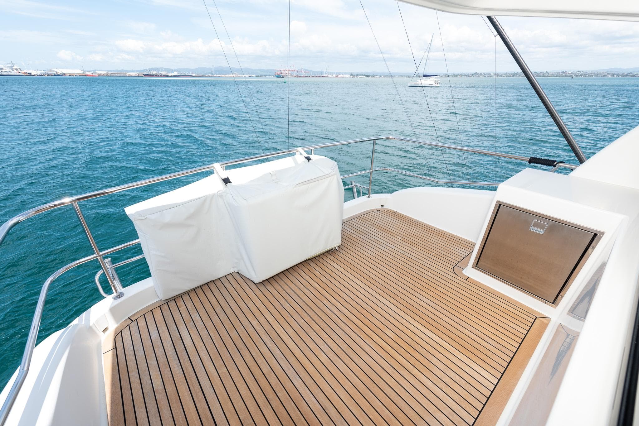 2021 Maritimo M51 yacht deck with teak flooring, overlooking serene ocean waters.