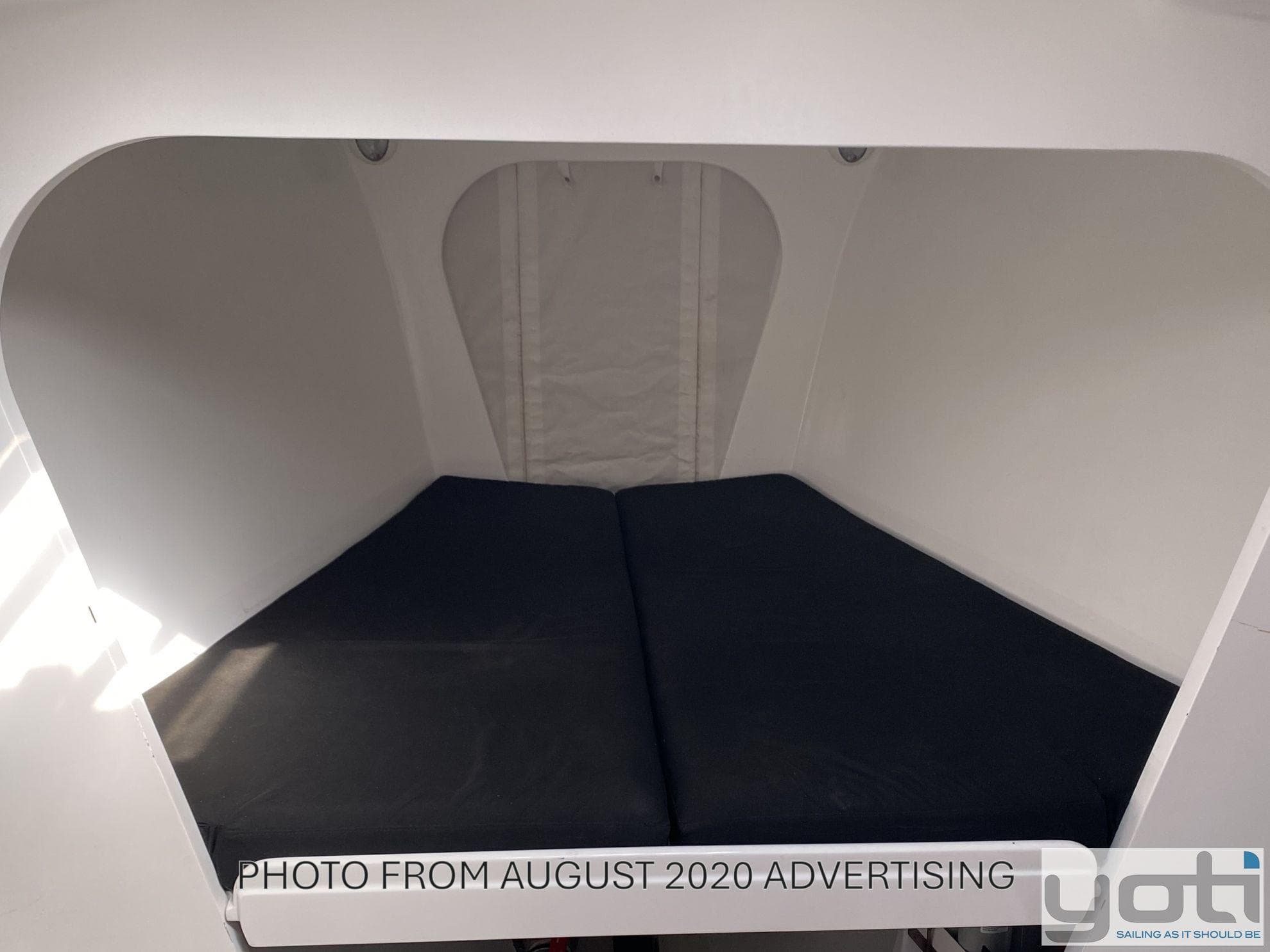 Cozy cabin interior of 1999 Custom Murray Burns Dovell 62 yacht with dark cushions.