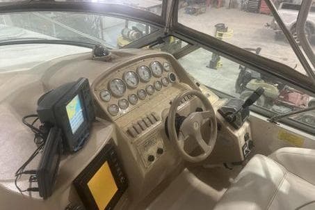 1998 Cruisers 3175 boat dashboard with gauges, steering wheel, and navigation equipment.
