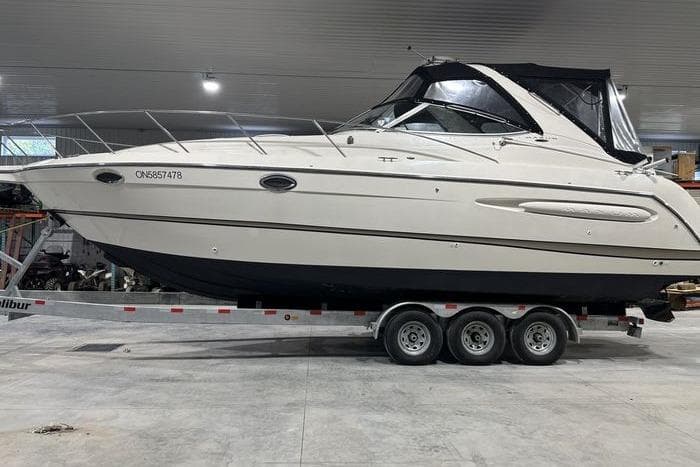 2001 Maxum 3300 SCR boat on a trailer in a garage setting.