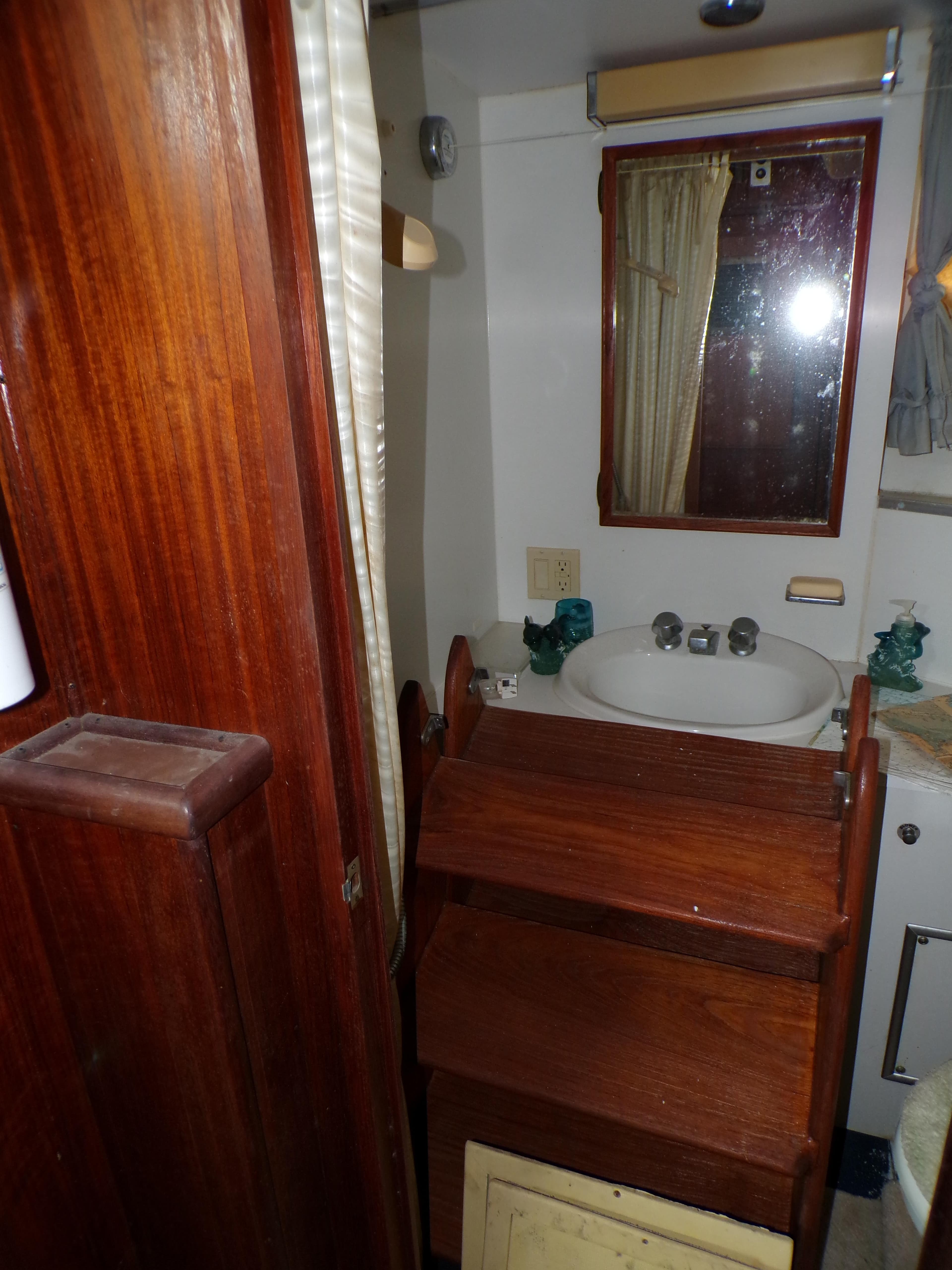 1978 Hatteras 58 Yacht Fisherman bathroom with wooden cabinetry and sink.