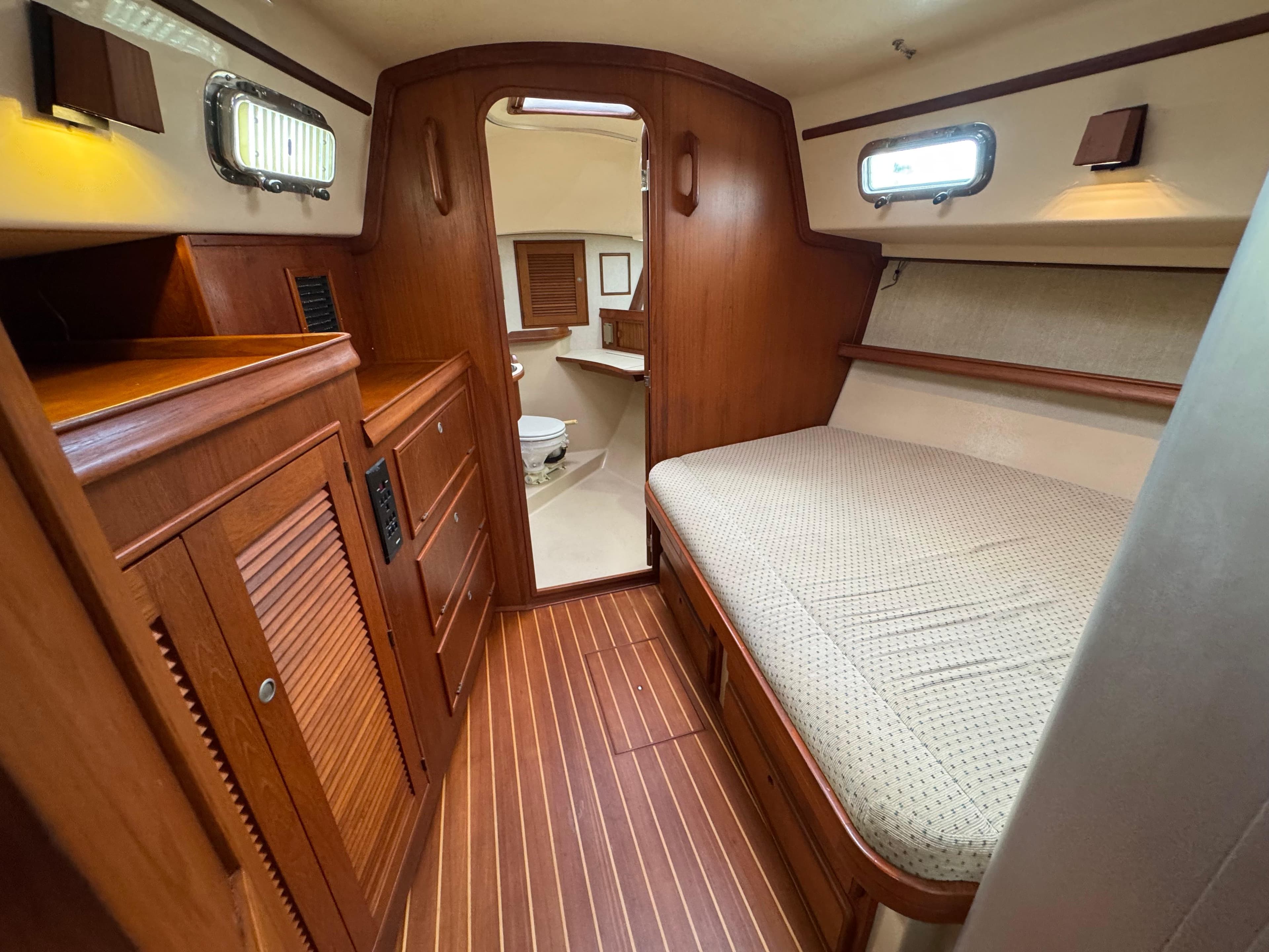 1999 Island Packet 45 interior cabin with wooden finish and cozy bed.