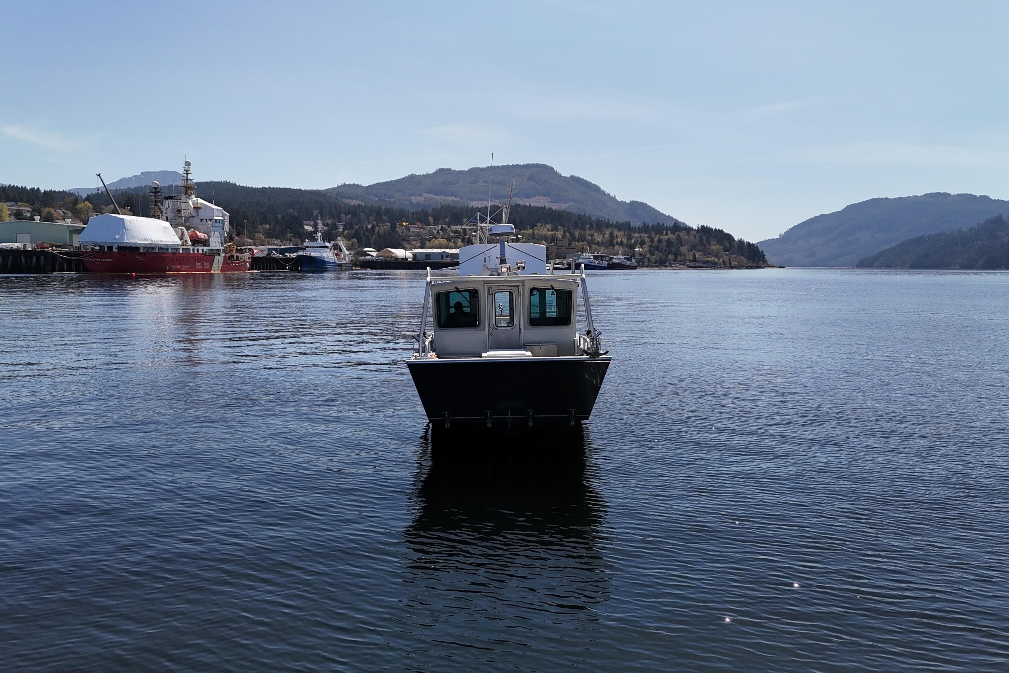2021 Silver Streak 32 Landing Craft Cabin on calm water with scenic mountain backdrop.