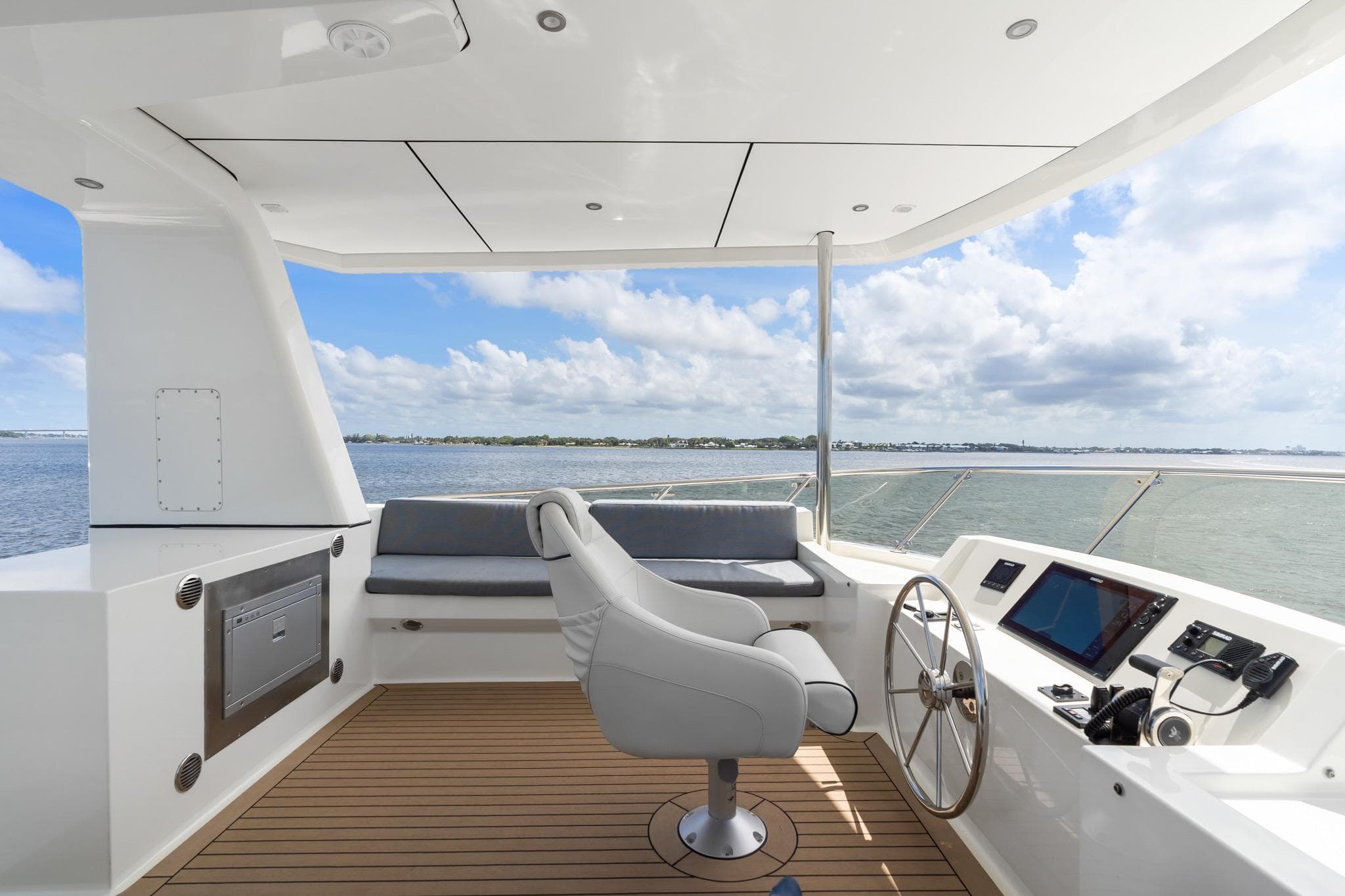 Luxurious helm of 2022 Alm Trawler Delfino 64 with panoramic ocean view.