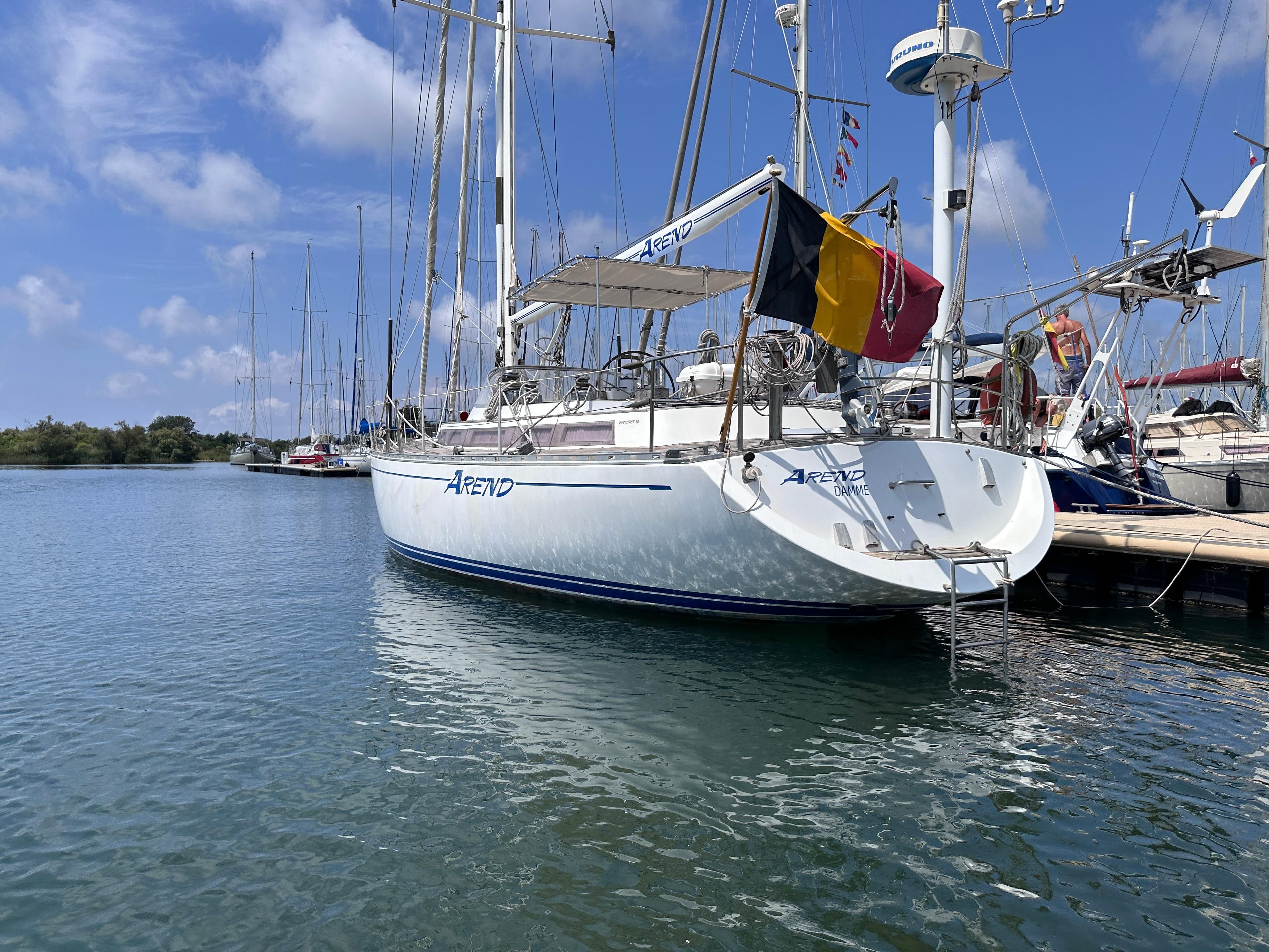 Sailboat "Arend" docked, Standfast 50 model, 1987, with Belgian flag, in a marina.