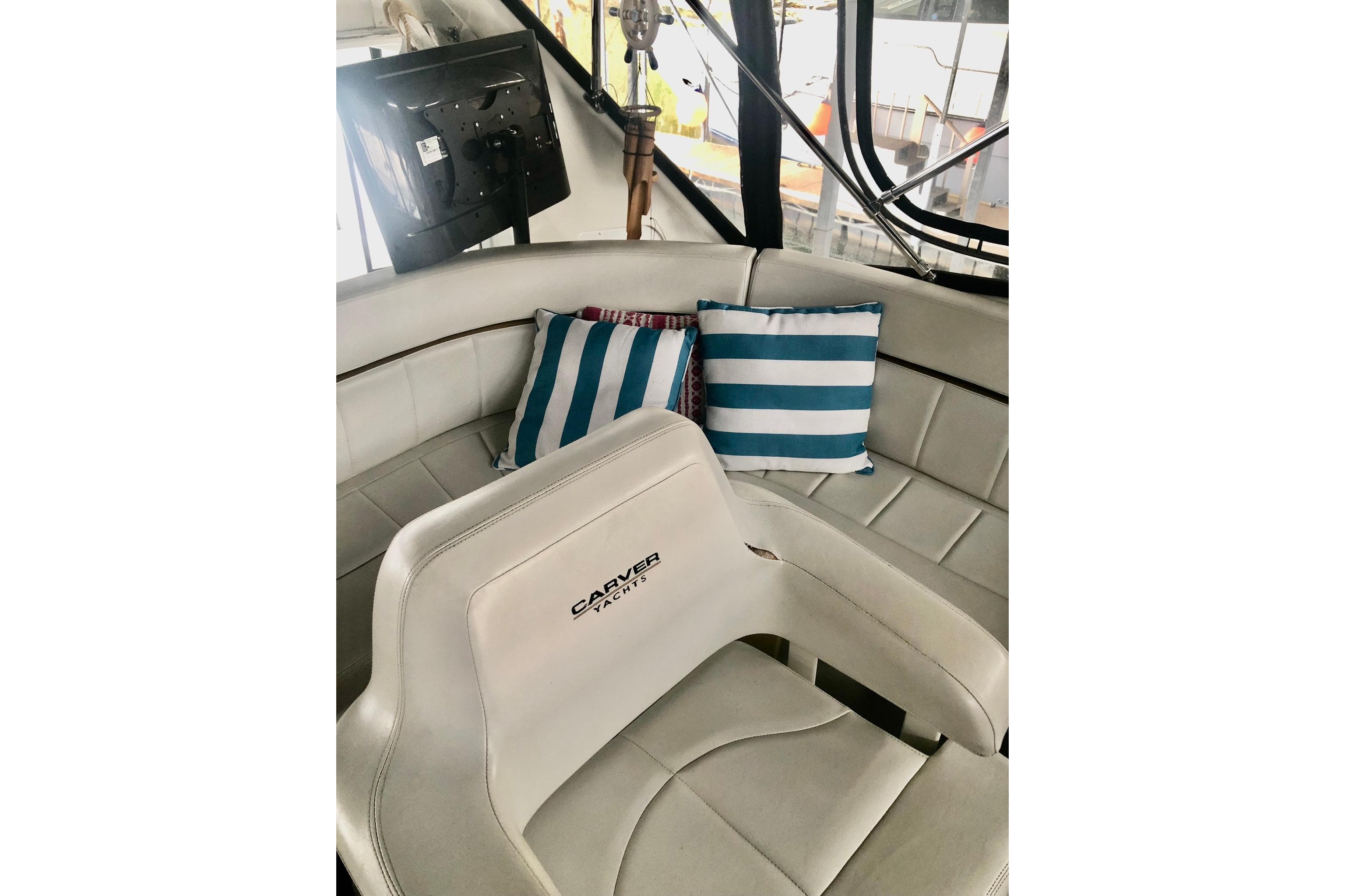 2005 Carver 444 Cockpit Motor Yacht interior with striped cushions and helm seat.