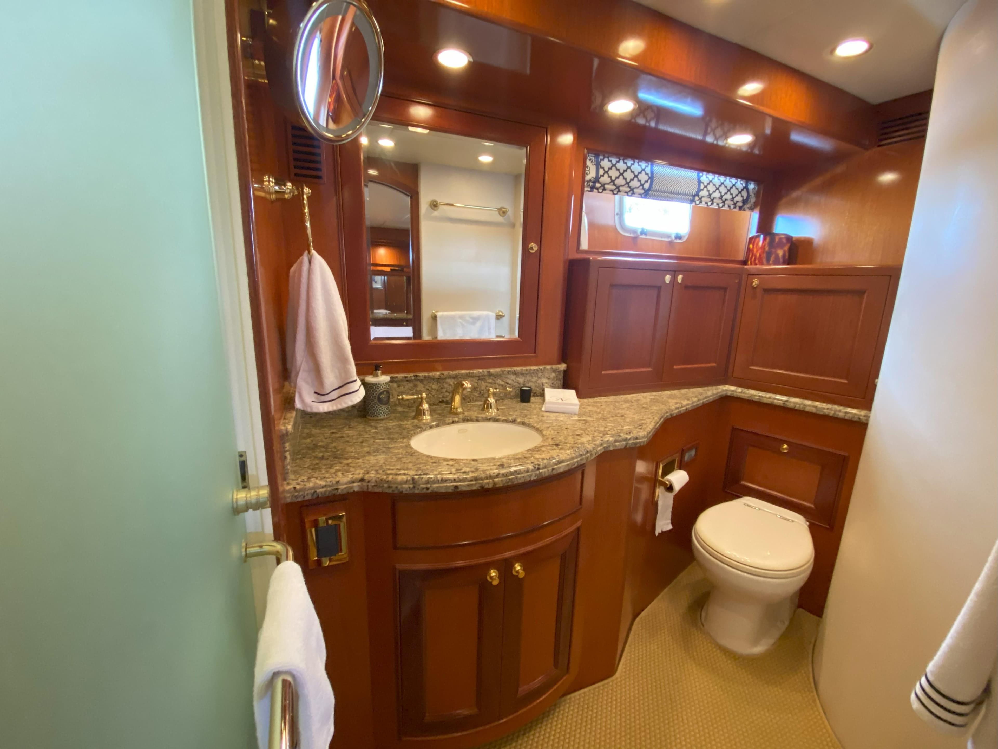 Luxurious bathroom in a 2005 Offshore Yachts 72' with wood cabinetry and granite countertop.